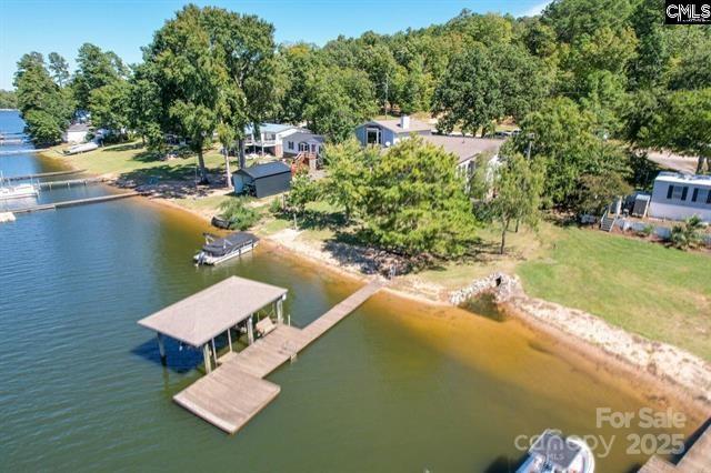 Beautiful home located in popular Beaver Creek at Lake Wateree. Home features a spacious great room with wood burning fireplace and hardwood floors. Upper owners suite highlights tree house views, bay window, private bath with separate shower, garden tub, huge walk in closet and double vanity. Main level entertains 3 bedrooms, 2 baths with a second owners suite option. For entertainment, home has a spacious sun room with bar and uncovered deck for outdoor grilling and sunshine! Enjoy great views and natural lighting through out with beautiful landscapes. Attached garage contains half bath with plenty of storage, extra storage under sun room and lake fed irrigation. Sunset views, sandy beach front, covered dock with boat lift and quick access to big water. Location is a golf cart ride to dining, marina and convenience store.