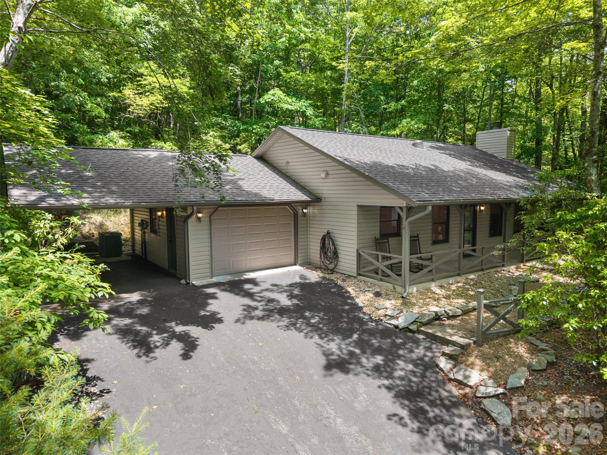 Completely remodeled in 2022, this 2-bedroom, 2-bathroom home offers 1,200 square feet of move-in ready living on a private 0.8-acre wooded lot in the gated community of Connestee Falls.
The open floor plan features hardwood floors, abundant natural light, and a floor-to-ceiling stone fireplace. The updated kitchen includes dark countertops, white cabinetry, stainless steel appliances, and an island with range hood. The primary bedroom includes shiplap accent walls and an updated en-suite bath with a barn door entry.
Outside, an attached 1-car garaged carport provide a place for cars and storage. A low-maintenance, tree-canopied lot provide easy upkeep and excellent privacy. The home is located a very short distance to Lake Tiaroga and Lake Ticoa as well as the Ecusta Trail system. 
As a Connestee Falls resident, you'll enjoy a full suite of amenities — clubhouse with dining, swimming pool, championship golf course, tennis and pickleball courts, four lakes, and miles of private hiking trails — all within minutes of downtown Brevard.
An affordable, fully updated mountain home with privacy, amenities, and year-round livability. Whether a primary residence or weekend retreat, this one is ready to go.