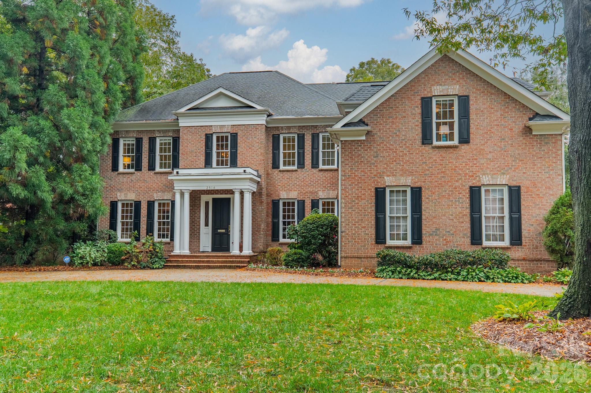 Exceptional outdoor living sets the stage for this retreat tucked away on a private .51 acre lot in the heart of Myers Park. Brick and bluestone terrace with outdoor fireplace and built-in grill, plus a lushly landscaped, level backyard ideal for entertaining or quiet evenings at home.  This full-brick Simonini built home features 10’ ceilings, rich hardwood floors, and sun-filled rooms throughout. The chef’s kitchen has professional-grade appliances, custom cabinetry, and a breakfast room wrapped in windows. Thoughtfully designed gathering spaces include formal living and dining rooms, plus a spacious great room with built-ins and a fireplace overlooking the backyard. A main-level guest suite offers flexibility for visitors or multi-generational living.  Upstairs, the primary suite is a true sanctuary with a spa-inspired bath, soaking tub, dual vanities, oversized shower, and a generous walk-in closet. An additional bedroom suite, two secondary bedrooms with a shared bath, and a bonus room complete the upper level.  The three-car garage, circular drive, and motor court provide ample parking for family and friends. Ideally located between Sterling Road and Ridgewood Avenue, just minutes from Myers Park Country Club, Reid’s, and The Jimmy. Welcome home!