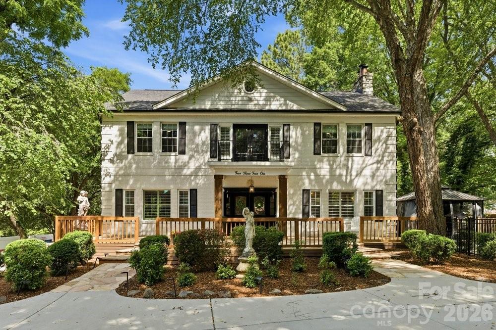 An exceptional opportunity in the heart of SouthPark, this thoughtfully updated 1920’s residence blends timeless architecture, generous living spaces, and a private half-acre setting just moments from Charlotte’s best dining, shopping, and schools. You'll be impressed the moment you step through the front door from the grand entry foyer with a sweeping staircase and soaring ceilings, to the natural light and character that carry through every room. The kitchen has been fully reimagined with new cabinetry, quartz countertops, and an oversized island that connects naturally to the main living areas. You will also find one of the home’s most compelling features on the main level: an additional suite, complete with a separate entrance, second fully remodeled kitchen with quartz countertops and custom hall tree, and attached bedroom. Whether it serves extended family, long-term guests, or a more tailored use of space, the flexibility it offers is endless. Upstairs, the primary suite includes a fully renovated bathroom with a soaking tub and custom closet built-ins, and a bookshelf-lined loft opening to a charming balcony right outside the door— making it an ideal reading nook, workspace, or play area. With 4 bedrooms, 3.5 bathrooms, a dedicated office, and an additional finished attic and basement —including a hidden wine vault— this home truly provides the space and flexibility to grow into over time. Outside, you’ll find two separate driveways for parking, a large porch, and the fully fenced half-acre delivers privacy that's difficult to find. A putting green and expansive lawn provide room to entertain, relax, or expand— with ample space to add a future pool. With walkability to Strawberry Hill shopping and dining, close proximity to SouthPark, and access to highly-rated private + public schools, it’s increasingly rare to find a home like this in a location that places you at the center of it all.