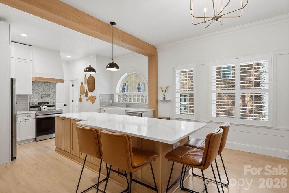 An exceptional opportunity in the heart of SouthPark, this thoughtfully updated 1920's residence blends timeless architecture, generous living spaces, and a private half-acre setting just moments from Charlotte's best dining, shopping, and schools. From the grand entry foyer and sweeping staircase to the soaring ceilings and abundant natural light, the home strikes a rare balance between historic character and modern functionality. One of its most compelling features is found on the main level: a private guest suite with a separate entrance, fully remodeled kitchenette, and an adjoining room ideal for multi-generational living, hosting guests, a private office, or even a formal dining room. With nearly 4,700 usable square feet across multiple levels—including a dedicated office, finished basement, and finished attic—this home provides the flexibility to adapt as your needs evolve over time. The primary kitchen has been fully reimagined with new cabinetry, quartz countertops, and an oversized island that connects naturally to the main living areas. Upstairs, the primary suite includes a fully renovated bathroom with a soaking tub and custom closet built-ins, along with a bookshelf-lined loft opening to a charming balcony just outside the door—making it an ideal reading nook, workspace, or play area. Outside, two separate driveways provide ample parking, while the fully fenced half-acre lot delivers privacy that's increasingly difficult to find. A putting green and expansive lawn provide room to entertain, relax, or expand—with plenty of space to add a future pool. With walkability to Strawberry Hill shopping and dining, close proximity to SouthPark, and access to highly-rated private and public schools, it's increasingly rare to find a home like this in a location that places you at the center of it all!