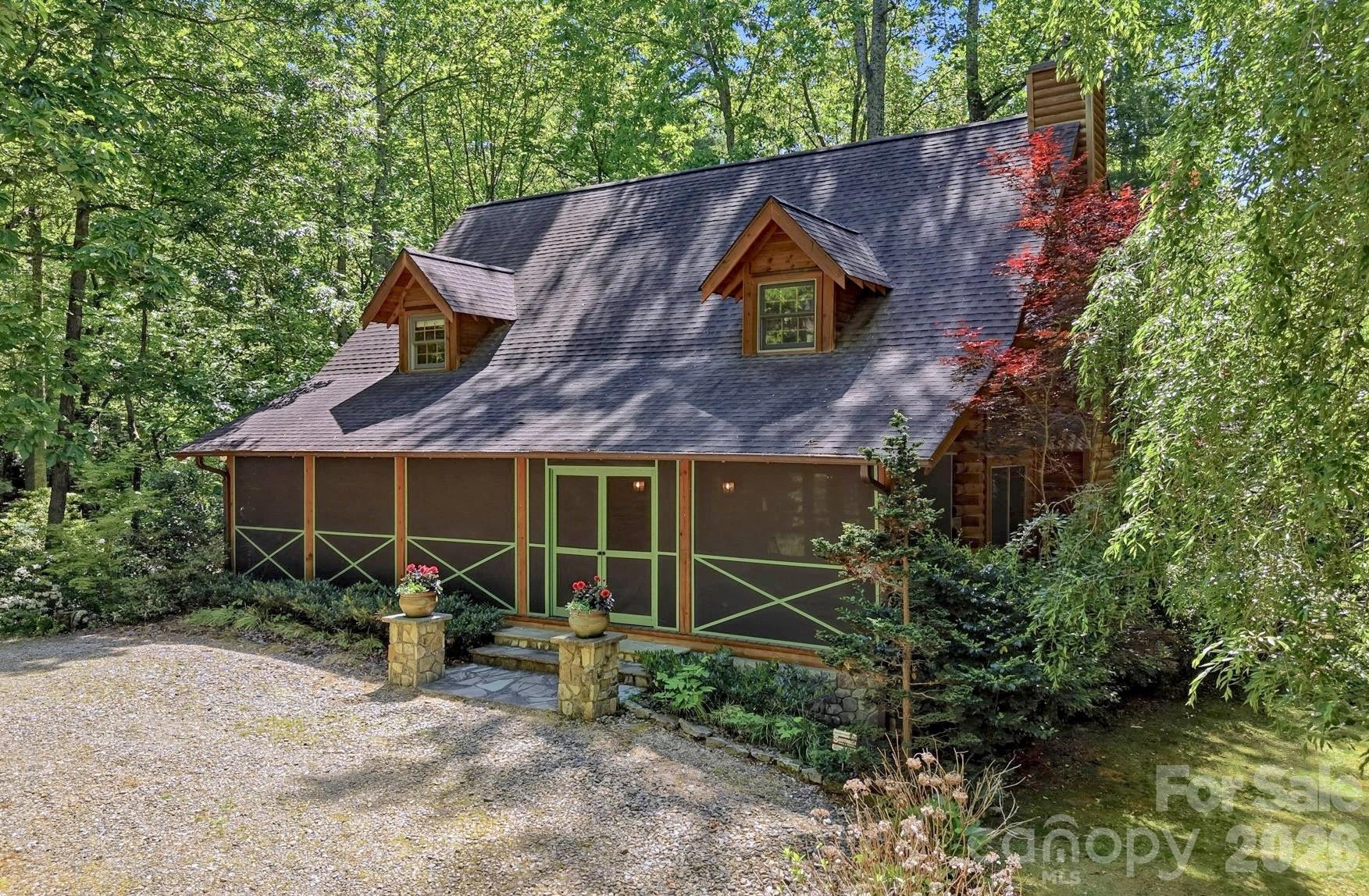 A beautifully updated mountain retreat nestled into a cozy, wooded, and walkable neighborhood just outside of Flat Rock — offering that rare balance of peaceful mountain living while still being incredibly convenient to everything Hendersonville has to offer, with easy access to I-25 and I-26. Set on 1.49 private acres with a stream winding through the property, this is the kind of home that immediately slows you down. Spend mornings on the screened front porch listening to the birds with a book in hand, or host friends and family on the expansive new Deckorators deck under the glow of string lights for holidays and summer evenings to come.

The home lives comfortably for both full time living and weekend escapes, with a main level primary suite, en suite bath, and generous closet space for storage. Throughout the cabin, thoughtful details like fun lighting fixtures, etched frosted glass doors, and tasteful renovations give the home character without losing its warm mountain charm.

16 Shadow Brook Drive feels nostalgic in the best way — bringing you back to those carefree days when discovering the woods felt like an adventure and summers felt endless. With deeded access to Lake Summit, you can spend your days on the boat, at the beach, or simply enjoying the relaxed mountain lifestyle that makes this area so beloved.