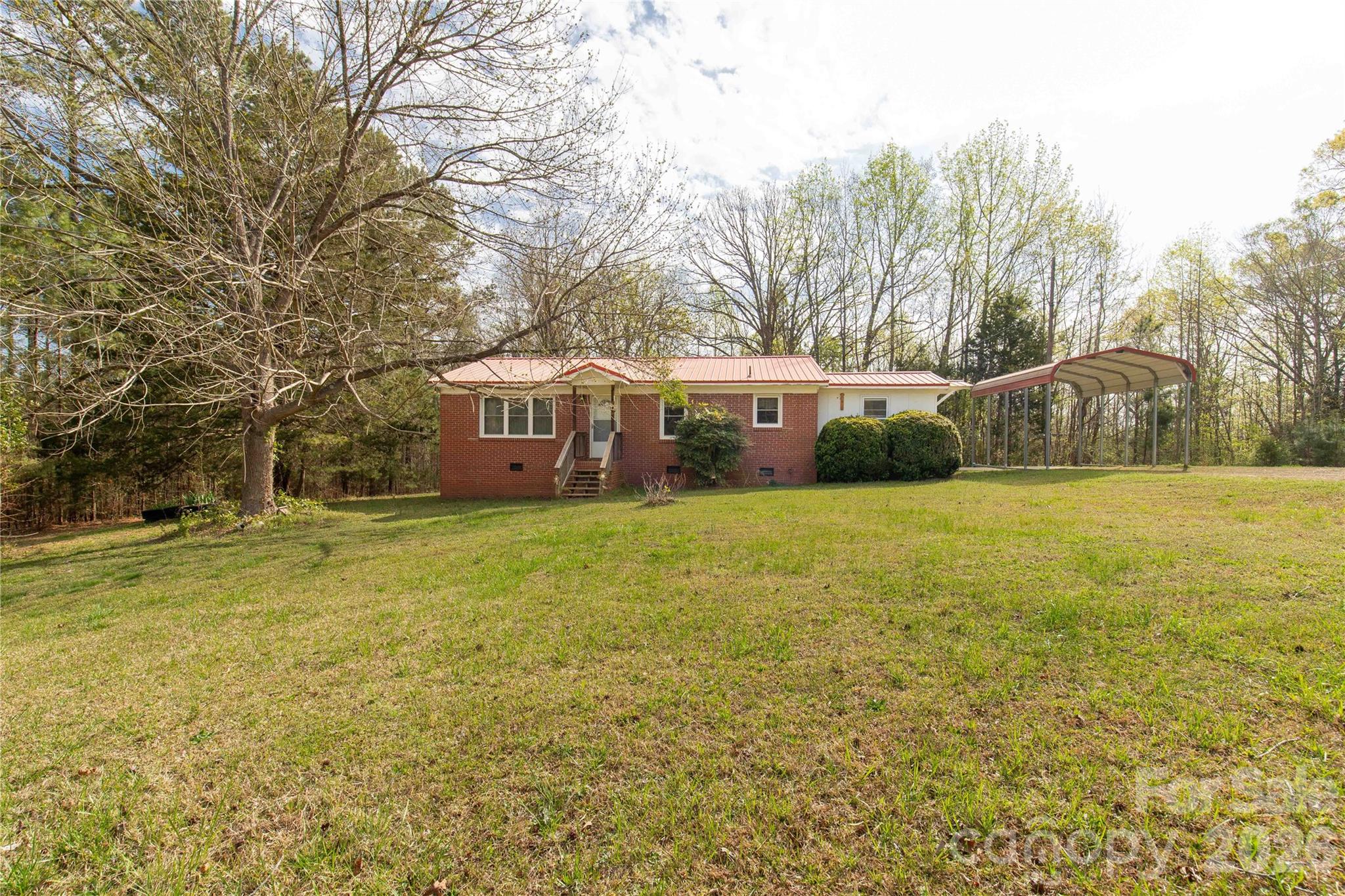 Brick ranch located in the highly desirable Buford School District offering a rare blend of usable acreage, functional improvements, and relaxed rural living on 2.8 acres. This 3 bedroom, 1 bath home features a comfortable and efficient layout with a kitchen equipped with a stove, refrigerator, breakfast bar, dining area, and pantry. Warm knotty pine paneling flows through the kitchen and into the living room, adding character, texture, and a cozy cabin-like feel that sets this home apart from typical ranch-style properties.
A durable metal roof enhances durability and peace of mind, while the brick workshop expands the possibilities for storage, hobbies, tools, or creative projects.  Outside is where this property truly shines. The 2.8 acres offer room to spread out, garden, host gatherings, enjoy outdoor living, or explore small homestead-style use. Whether you envision space for animals, a firepit hangout area, or simply extra elbow room between you and neighbors, this property delivers that increasingly hard-to-find sense of privacy and flexibility. Two camper hookups are also in place for added utility.

This is an excellent opportunity for a first-time home buyer or anyone seeking affordability paired with land ownership in Buford School District. A property like this offers more than just a home—it offers breathing room, usability, and the chance to shape the land & home into your own vision, all while staying conveniently located to everyday essentials.