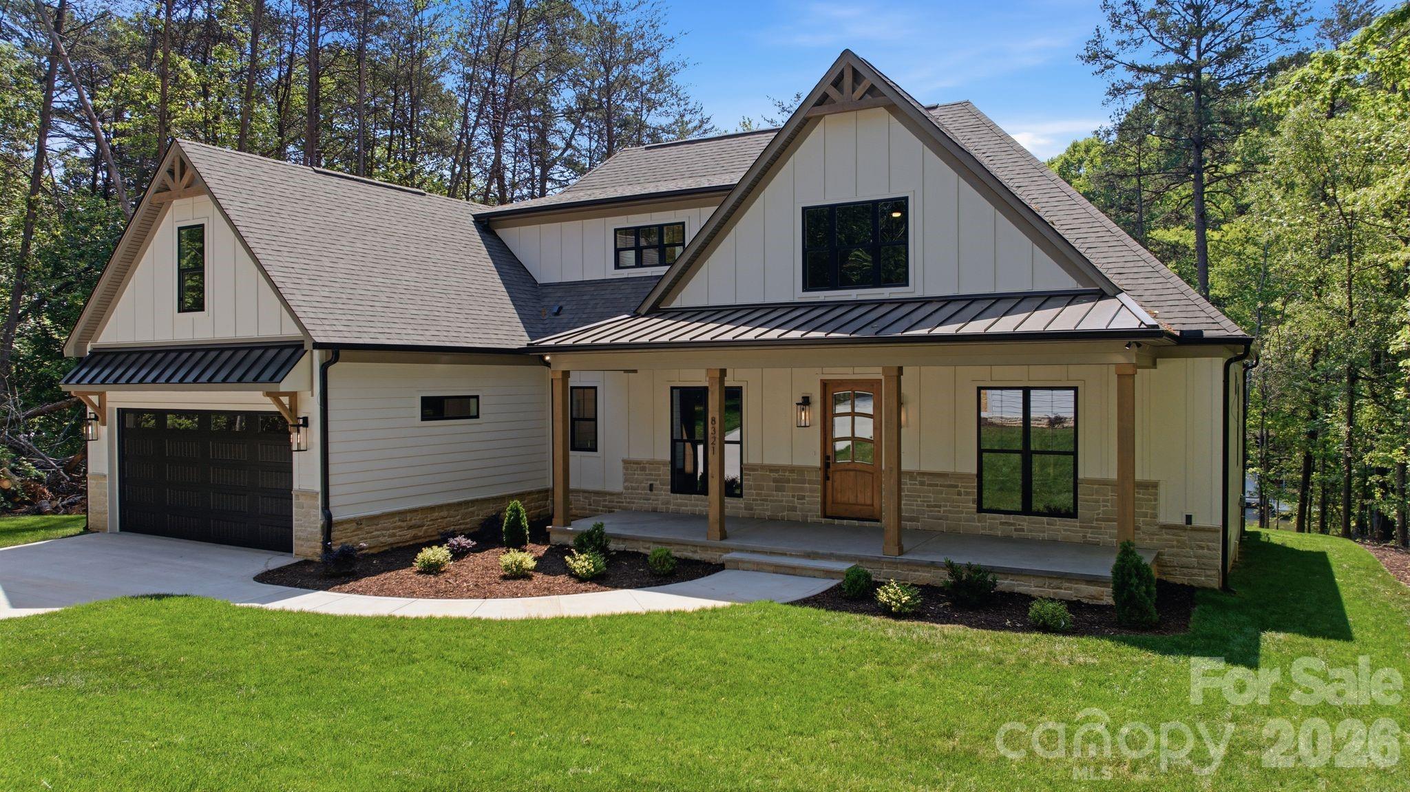 Set at the end of a long private driveway, 8321 Long Island Road offers 1.29 acres of waterfront privacy paired with new construction by Modlin Custom Homes completed in 2026. Spanning 4,328 square feet, this 4 bedroom, 4 bathroom residence is thoughtfully designed with a main level primary suite, open living areas, and abundant natural light throughout, creating a home that feels both elevated and comfortable. A custom solid entry door sets the tone as you enter inside, where quality craftsmanship and custom millwork carry throughout the home. The main living spaces are open and well proportioned, offering a natural flow between the kitchen, dining, and living areas. Large windows frame the water and bring in soft natural light, while the transition to the expansive covered deck creates a seamless indoor to outdoor connection that works well for both everyday living and hosting. The primary suite on the main level is positioned for privacy and offers a calm, well appointed retreat with a beautifully finished bathroom. A separate guest suite on the main level provides comfort for visitors, while an additional flex room offers versatility as an office, or den depending on your needs. Upstairs, the layout continues with two spacious bedrooms, a large bonus room, and a dedicated media room, giving you flexibility for entertaining, relaxing, or creating additional living space tailored to your lifestyle. The outdoor setting is equally inviting, with a private dock that makes it easy to enjoy the lake, whether it is an early morning boat ride or a quiet evening watching the sunset. The 1.29 acre lot provides a sense of space and privacy that is hard to find. The property also includes four garage spaces, featuring an attached garage and an oversized detached two car garage, offering ample room for vehicles, storage, or recreational gear. This is a setting that feels tucked away and private while still keeping you close to everything that makes Lake Norman such a sought-after place to live.