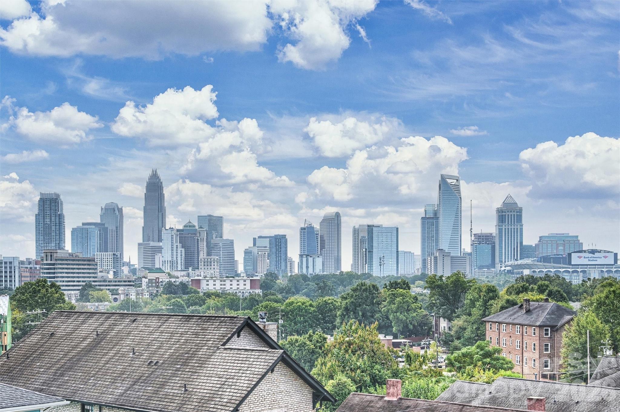 Rooftop townhome with panoramic Uptown Charlotte skyline views and a terrace designed for unforgettable evenings. Rare move-in ready 3-bedroom rooftop townhome featuring an impressive list of interior upgrades, including a dry bar, hardwood floors throughout, custom blinds, and a flexible floor plan designed for modern living. Freshly painted and flooded with natural light, oversized windows are thoughtfully positioned to showcase the dramatic city skyline. The expansive rooftop terrace faces directly toward Uptown, creating a breathtaking backdrop for entertaining or relaxing while enjoying sweeping skyline views that stretch for miles. Ideally located just minutes from Center City, blocks from the Greenway, and two blocks from the Lynx Gold Line Wesley Heights Station, this home offers unmatched convenience. Neighborhood favorites—including Pinky’s, Burger Company, Rhino Market, Town Brewing, and a host of new dining and gathering spots—are just steps away, and walkability continues to grow as the area develops. The lower-level third bedroom with a full bath provides an ideal space for guests, a private office, or a quiet retreat separate from the main living areas. With a two-car garage and thoughtfully curated upgrades throughout, this home offers a rare opportunity to enjoy elevated city living with exceptional skyline views in a well-established, vibrant community.