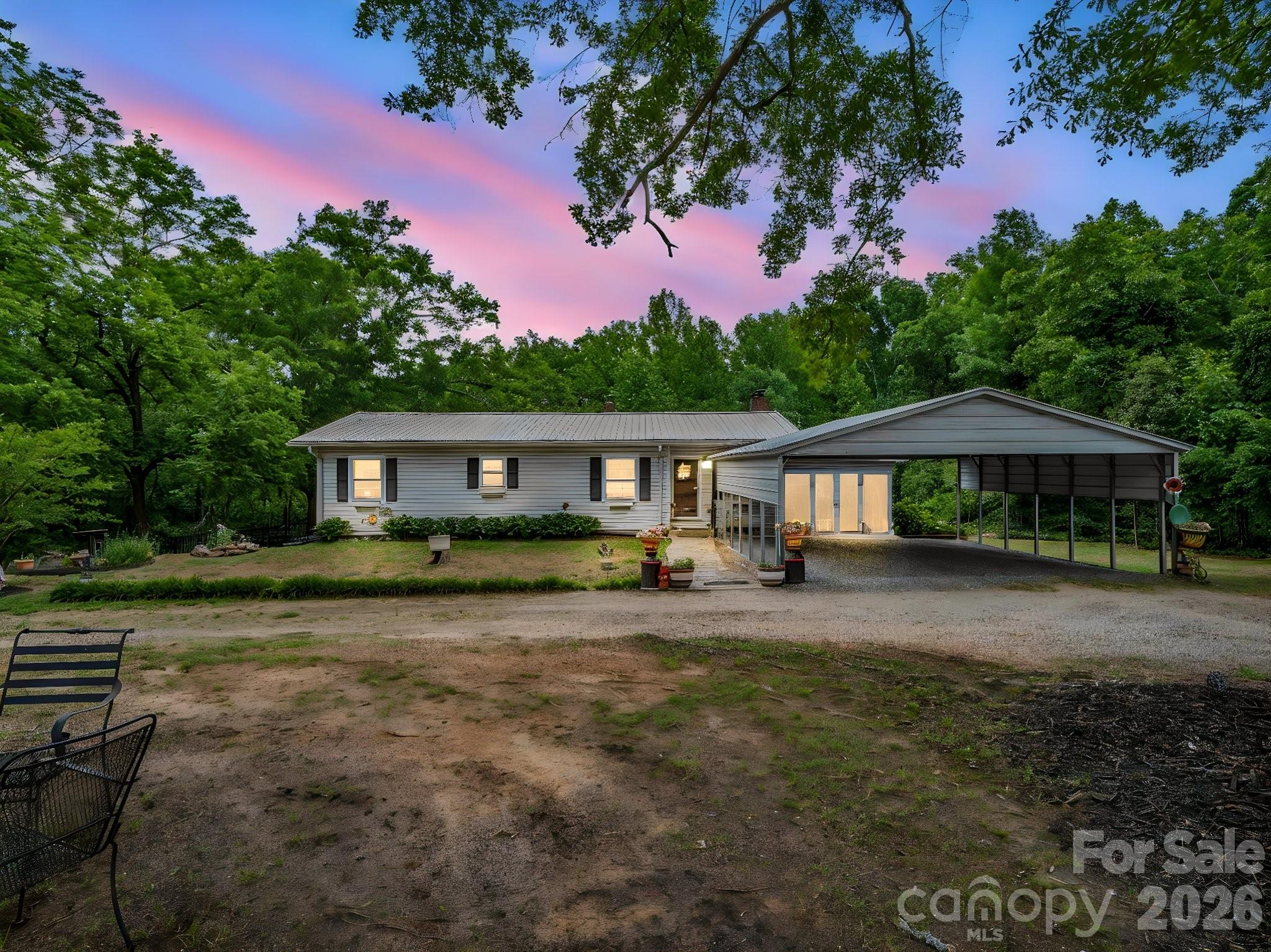 Lovely 3 BR, 2.5 bath home with lots of updates & situated on 3.65 acres! Updates include a new metal roof in 2022, new HVAC system in 2025, new flooring in kitchen, laundry rm, & 1/2 bath in 2022, new Anderson windows in basement and also sitting area on main level in 2024, new dishwasher 2024, new double metal carport in 2023.  As you enter the home, you'll find a sitting area with fireplace, the primary bedroom with ensuite bath & lots of closets, and the other two bedrooms with another full bath off the hall. The open staircase leads to the daylight basement with a large family room that has another fireplace, a large kitchen, the laundry room, and a half bath.  Lots of wood in this home with wood ceilings throughout. There is also a carport attached to the home but it has been closed-in for storage.  At the back of that carport is a small workshop area. There are three storage buildings. A concrete drive leads to a large patio out back that is partially covered - great for enjoying the private backyard or entertaining!  The backyard also has a firepit and a fenced area for your pets.  There's a space for an RV and there are hookups but sellers have never used them and do not guarantee that they still work. Home is very clean & move-in ready!  Convenient to Hwy 74 and approx. 1 hour to Charlotte, Spartanburg/Greenville, or Asheville. Don't miss this one!