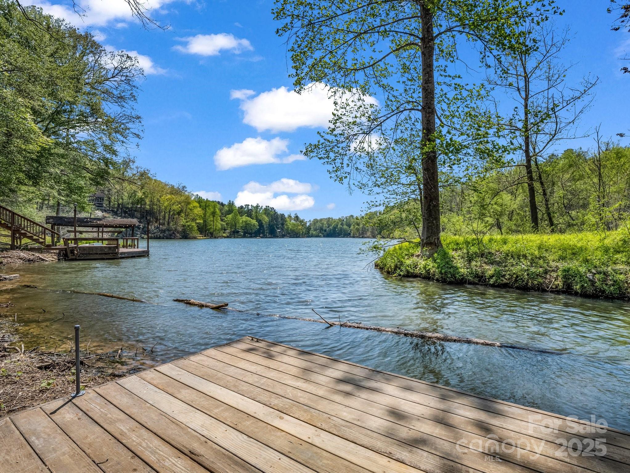 Enjoy the best of both worlds—peaceful lakefront living on the quiet north end of Bald Mountain Lake and access to Lake Lure and all the premier amenities of the Rumbling Bald on Lake Lure community. Nestled in a private cove on this scenic one-mile, non-motorized lake, this property offers the perfect setting for kayaking, paddleboarding, canoeing, fishing, swimming, or simply relaxing from your private dock.

Rumbling Bald amenities include 24-hour security, private beach access, indoor and outdoor pools, tennis and pickleball courts, additional sports courts, two championship 18-hole golf courses, a fitness center, full-service spa and salon, restaurants, bars, and more.

The home has been thoughtfully updated, including a brand-new roof and exterior paint completed in April 2025. Main dock and floating dock resurfaced with Trex decking June 2026. Inside, the open-concept main level features a spacious great room anchored by a stunning floor-to-ceiling stone wood-burning fireplace. The kitchen offers granite countertops, stainless steel appliances, and flows seamlessly into the dining area overlooking the level backyard and fire pit.

The main level includes a primary suite, guest bedroom, and full guest bath. The lower level provides two additional bedrooms, a full bath, family room, and recreation room complete with a pool table—ideal for hosting family and friends. A screened porch overlooks the backyard, providing a comfortable space to enjoy the outdoors year-round.

Additional features include ample parking and a strong rental history, making this an excellent primary residence, vacation home, or investment opportunity. Contact listing agent for rental history. Available turnkey.