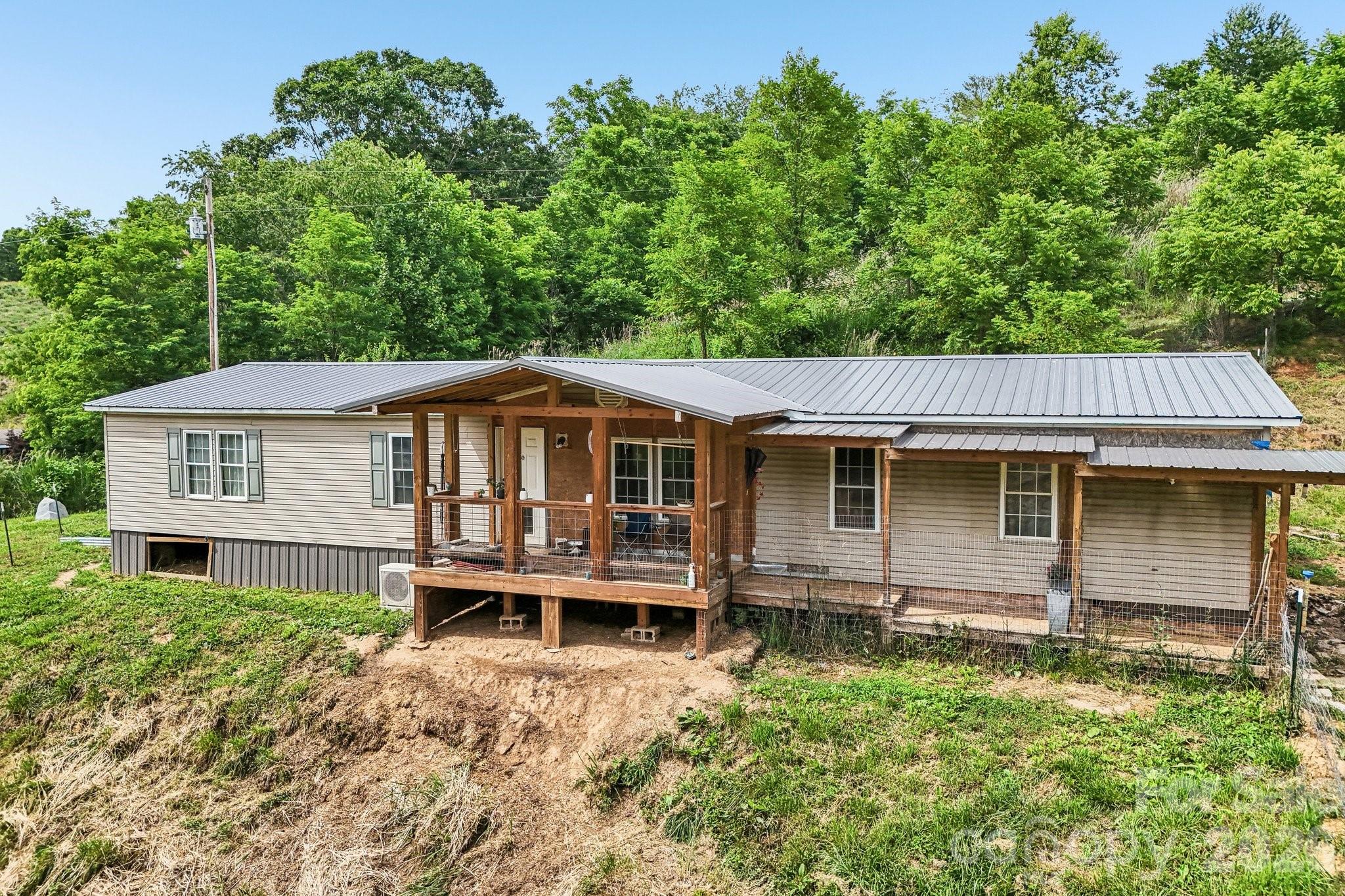Nestled in the peaceful countryside, this charming 5.87-acre property offers the perfect blend of rural beauty, functionality, and investor opportunity. The doublewide sits on a gently rolling parcel surrounded by a pasture area, barn, outbuildings, chicken coop and another potential cottage for a small vacation rental. 
There is a pond that needs cosmetic revamping to bring it back to its glory. This could create a tranquil setting for relaxing or simply enjoying the natural surroundings. The fenced pasture offers ample space for a horse, other livestock, goats  etc. and could make a great hobby farm. The barn provides storage, shelter, and versatility for agricultural or recreational use. Adding even more value to the property is a separate partial structure that once served as a residence. With renovation and vision, this building could potentially be restored into a guest house, rental property, workshop, studio or additional living space, making it an exciting opportunity for those seeking a property with future potential.
Whether you're looking for a small farm, a homestead or peaceful country retreat, this unique property combines open acreage, useful outbuildings, water features, and renovation possibilities in a beautiful rural setting. Enjoy the freedom of country living while still having the convenience of town within a reasonable drive.