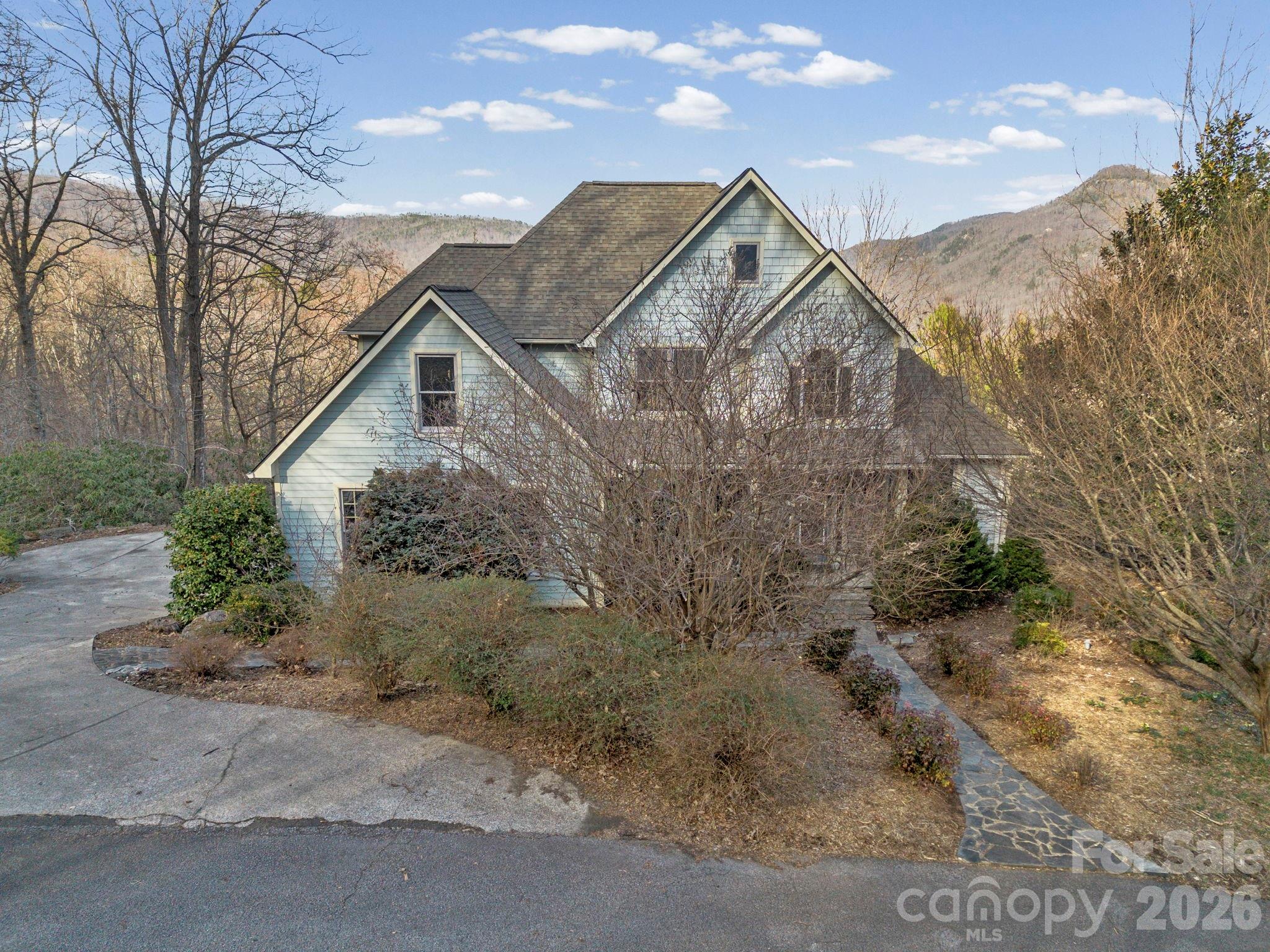 Perfectly positioned within the Rumbling Bald community, this stunning mountain retreat offers an exceptional combination of privacy, architectural character, and breathtaking natural surroundings. Situated as the second-to-last home on a quiet dead-end road, the property offers remarkable peace and sweeping mountain views while also providing resort-style amenities. Inside, the living room is anchored by a dramatic two-story stone gas fireplace, creating a warm and inviting focal point for the home. The thoughtful floor plan offers the perfect balance of open concept and defined spaces—ideal for everyday living and entertaining. Large windows bring in abundant natural light and highlight the beautiful surroundings. Admire the warm wood floors throughout the home and the beautiful cherry cabinets, two ovens, and a gas cooktop in the kitchen. Accessible from both main floor bedrooms and the living room, step out to the east-facing back deck with low-maintenance Trex decking, the perfect setting for soaking in the morning sun, mountain breezes, and quiet evenings overlooking the fenced in backyard. The grounds are beautifully curated for low-maintenance mountain living, featuring mature rhododendrons, flowering perennials, a graceful magnolia tree, and charming stone walkways + covered sitting area that complement the home’s tranquil setting. This lovely home has a 3 bedroom septic plus an additional office space and large bonus room upstairs- so plenty of room for all your loved ones! Would make a fantastic full-time residence or short-term rental. Rumbling Bald amenities include two championship golf courses, three resort pools (with a lazy river), tennis and pickleball courts, private beach with lake access, hiking trails, mini golf, a fitness center, multiple on-site restaurants and more. Be a part of Lake Lure's revival; they've begun the refill process, and the lake is expected to be open for recreational use by Memorial Day!