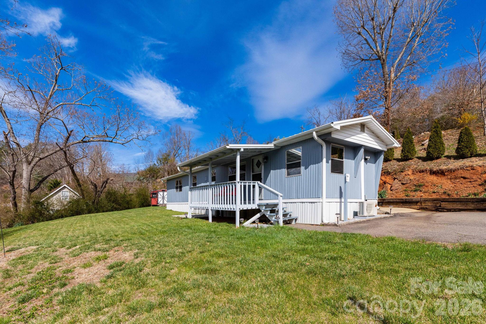 Well-maintained and move-in ready, this updated singlewide in Weaverville offers affordability without sacrificing convenience. Featuring LVP flooring, two newer mini-splits for efficient heating and cooling, and a functional layout, this home is ideal for buyers looking for low-maintenance living.

Enjoy the added value of an attached one car garage, washer/dryer hookups, city water, and a paved shared driveway for easy access. A covered front porch provides a welcoming space to relax and enjoy the surroundings. A propane wall heater offers reliable backup heat which is an excellent feature during power outages.

The ceiling height throughout the home is 6' 10" and therefore can't be advertised as heated space.

Located just minutes from grocery stores, downtown Weaverville dining, and only a short drive to Asheville.

Opportunities like this don’t last. Schedule your showing today.