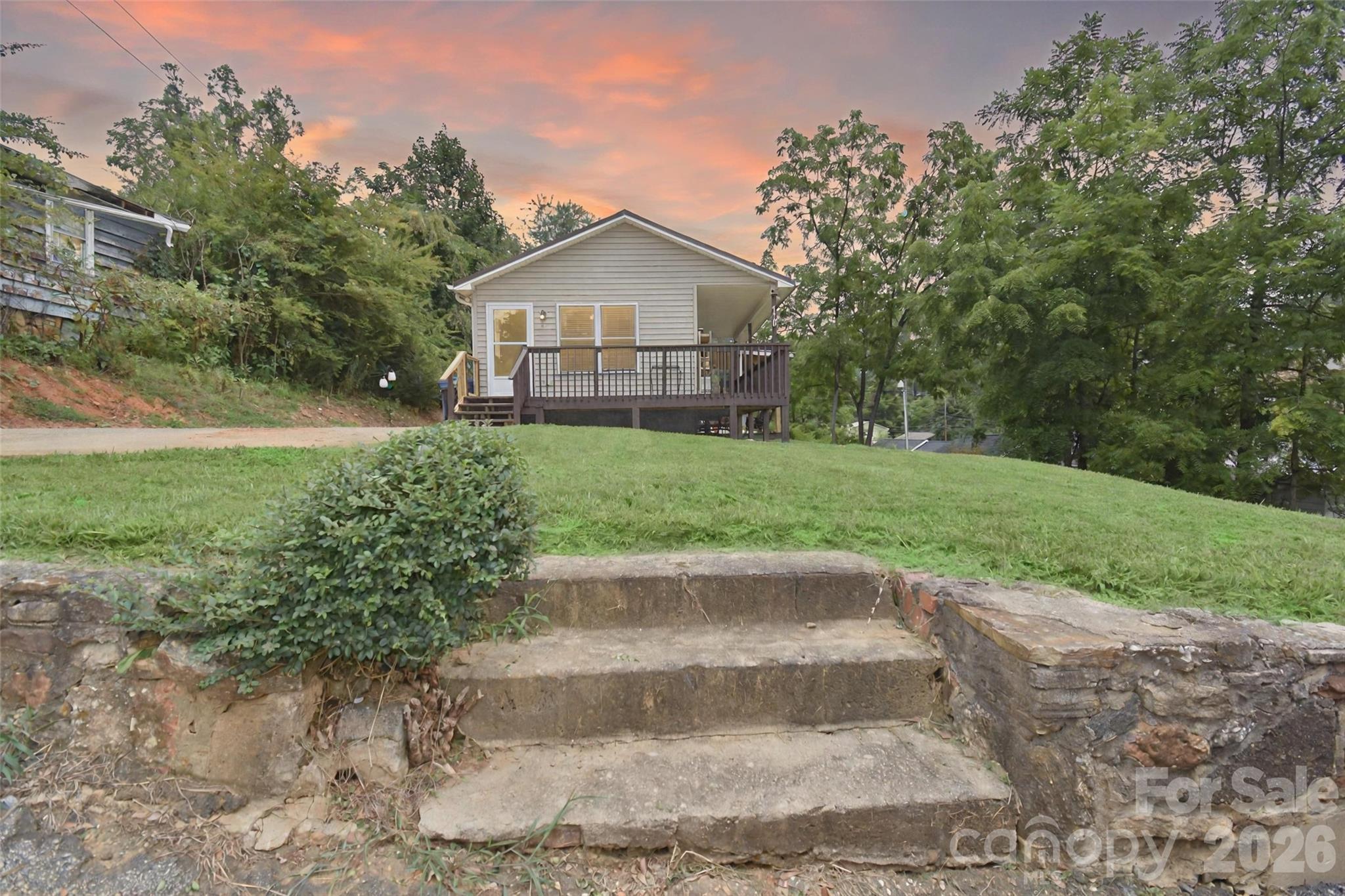 Discover this charming, meticulously maintained home in desirable vibrant downtown Brevard. Thoughtfully designed with an efficient footprint, this cozy retreat maximizes every square foot while delivering an exceptional outdoor lifestyle that feels expansive and luxurious.
Step onto the spacious wrap-around deck—ideal for quiet morning coffee or sunset relaxation—and descend to the generous lower deck built for effortless entertaining with friends and family. The beautifully utilized yard offers surprising scale and privacy, with room for play, gardening, or simply enjoying the fresh mountain air. Gather around the inviting firepit for cozy evenings under the stars, and take advantage of the dedicated side area perfect for outdoor furniture, grills, or recreational gear.
Inside and out, this home seamlessly blends comfortable, low-maintenance living with abundant outdoor spaces that extend your lifestyle year-round. Located near Brevard’s shops, restaurants, and cultural scene, it truly offers the best of both worlds. Photos capture the appeal, but this one shows even better in person—schedule your private tour today!
