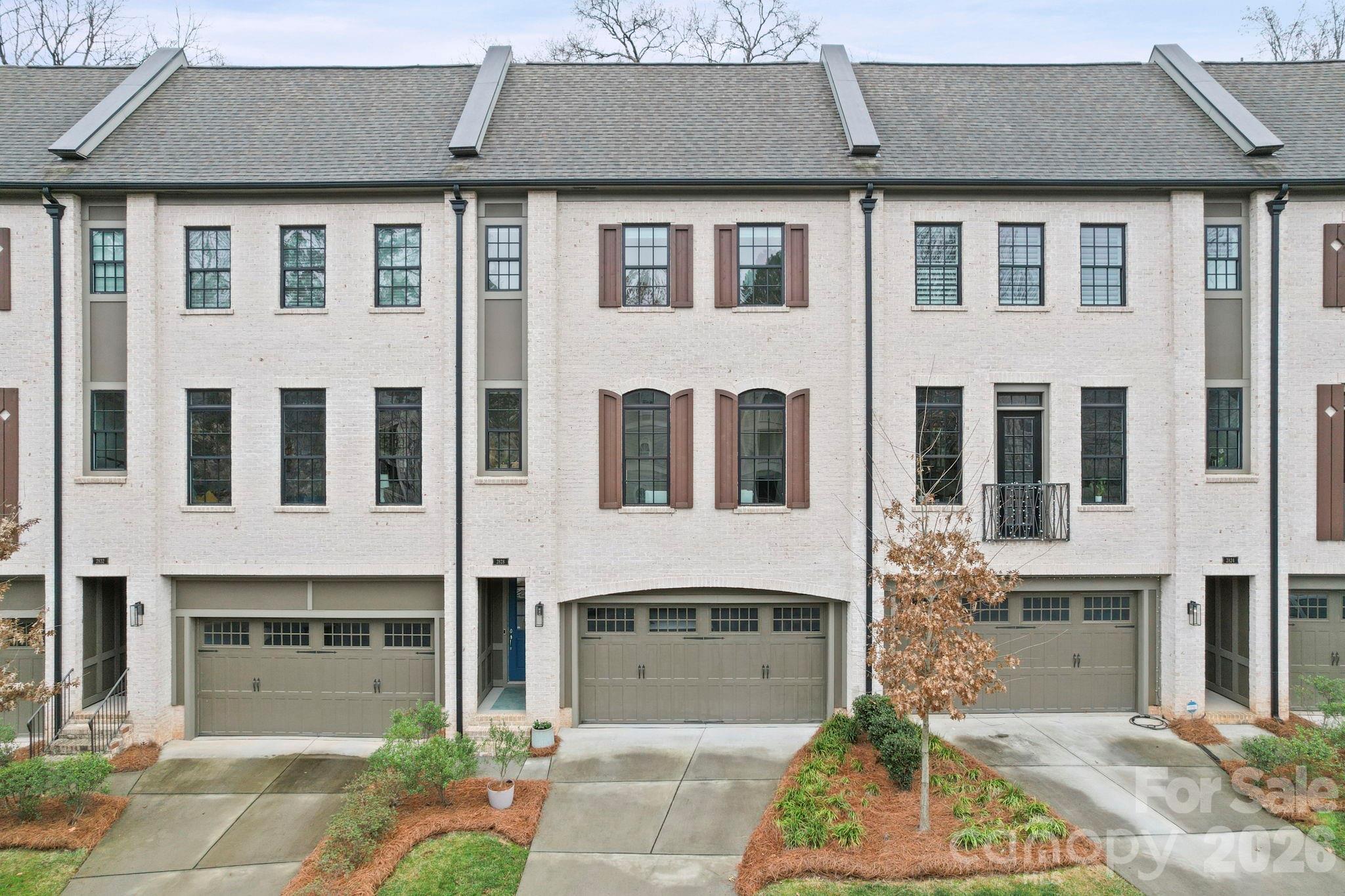 Welcome to the lifestyle you’ve been waiting for.
Sunlight pours through oversized windows and dances across gleaming hardwood floors in this stunning Hillside Towns luxury townhome — where every detail has been curated for those who refuse to settle. From the moment you step through the elegant foyer, you’ll feel the difference that 10-foot coffered ceilings, custom built-ins, and a gas fireplace make in a space you’ll actually want to come home to. And just off the kitchen and dining area, a gorgeous screened porch invites you to linger over morning coffee or evening cocktails while taking in a peaceful wooded backdrop.

The heart of this home is a showstopping chef’s kitchen that will make you want to cook — and entertain. Anchored by a dramatic GE Café 36” dual-fuel gas range crowned with a sleek stainless steel hood, and finished with stunning countertops and a designer tile backsplash, this kitchen is as beautiful as it is functional. Step through to the screened porch and your indoor-outdoor entertaining space becomes something truly special.

The sun-drenched living room is pure magic — a bright, airy retreat filled with natural light that makes every day feel like a breath of fresh air.

Three generously sized bedrooms each feature a private bath, walk-in closet, and nearby laundry — plus a private lower-level guest suite with terrace access for guests who may never want to leave.

And the location? Unbeatable. Tucked just minutes from Uptown Charlotte and SouthPark, you’re also walking distance to Park Road Shopping Center, Freedom Park, and the Little Sugar Creek Greenway — the perfect blend of urban access and neighborhood calm.
Refined. Radiant. Ready for you.