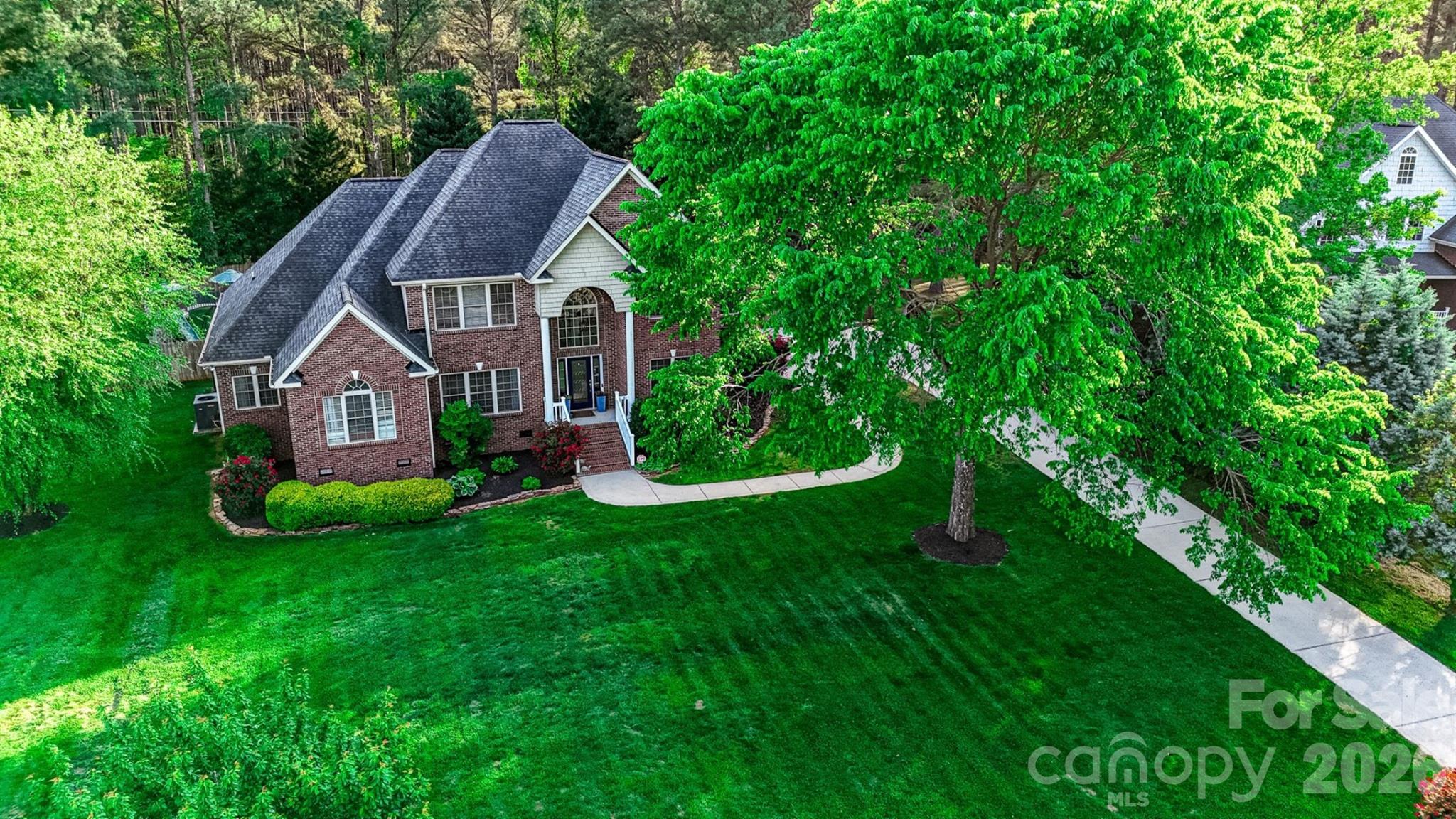 Tucked at the end of a quiet cul-de-sac in Patrick Place, this full-brick 4-bedroom, 3-bath home offers rare main-level flexibility: a true primary suite with double tray ceiling, dual walk-in closets, and spa bath — plus a second main-level bedroom and full bath, perfect for guests, in-laws, or one-level living.

The great room's vaulted ceilings and custom built-ins anchor an open floor plan that flows to a formal dining room and French-door office. Upstairs, two more spacious bedrooms, a full bath, a divided loft, and walk-in attic storage give everyone room to spread out.

The backyard is the showstopper: a fully fenced, private retreat with an expansive paver patio, built-in fire pit, integrated lighting, and multiple seating areas. A side-load 3-car garage, extra-long driveway, full-yard irrigation, and landscape uplighting complete the package.

Zoned for 9/10-rated Griggs Road Elementary and Clover High, minutes from Lake Wylie, with low SC taxes and just $46/mo HOA.