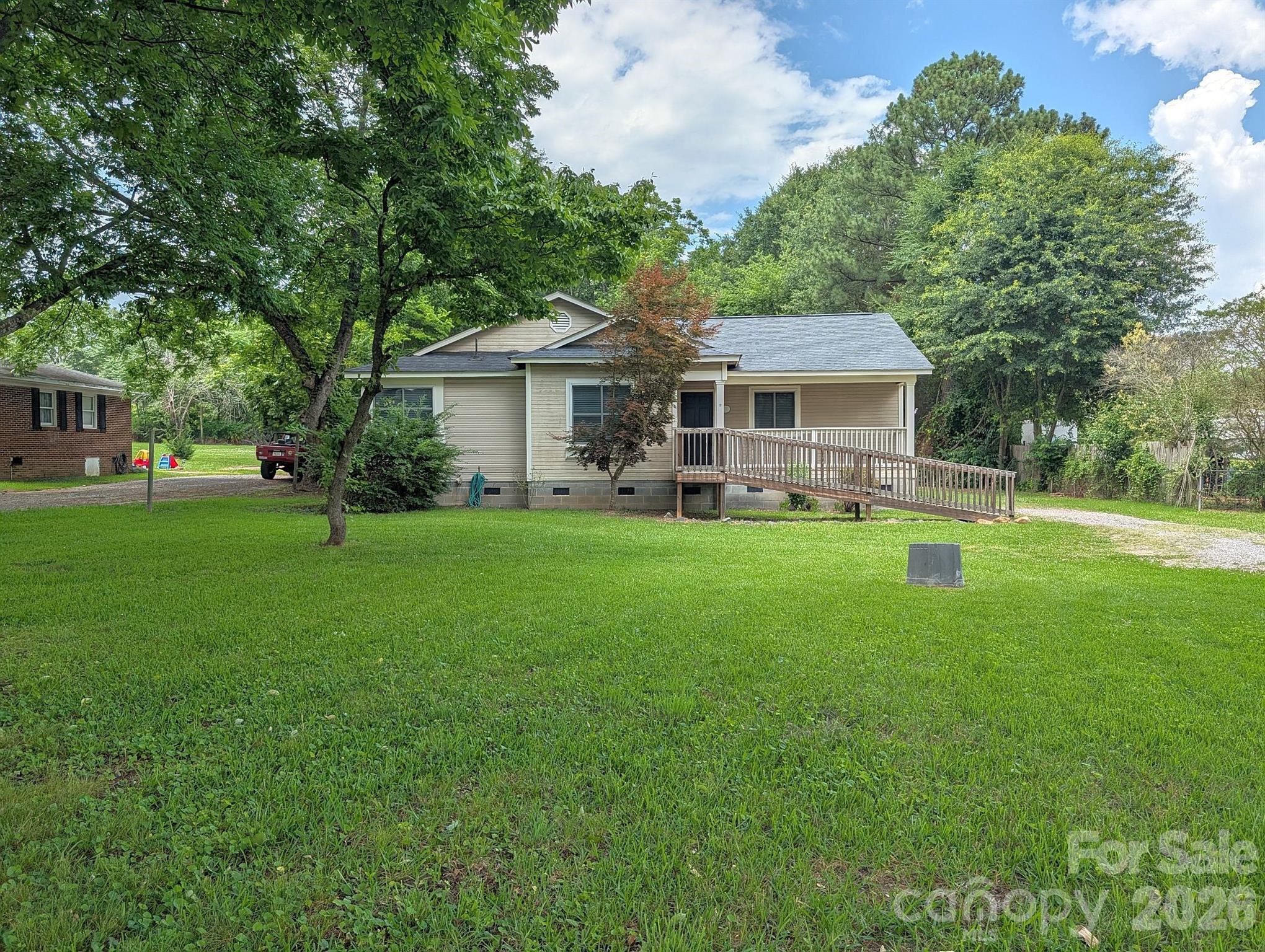 Welcome home to this charming 3-bedroom, 2-bath ranch situated on approximately 0.60 acres with a private backyard setting. Estimated at 1,288 square feet, this flexible floor plan offers the option of using one bedroom as a home office or study, complete with French doors for added character. New Anderson windows and sliding glass doors too, with in the last year!!

The spacious family and dining area features a vaulted ceiling and sliding glass doors that open to the covered back porch, creating a seamless connection between indoor and outdoor living. The primary suite also offers private access to the back porch through sliding glass doors, along with a walk-in closet and an oversized double vanity featuring a dedicated makeup counter.

Enjoy relaxing mornings on the covered front porch with ramp access or unwind in the evening on the covered back porch with a porch swing overlooking the private backyard. Convenient, comfortable, and full of potential, this home offers peaceful living with room to enjoy both inside and out.