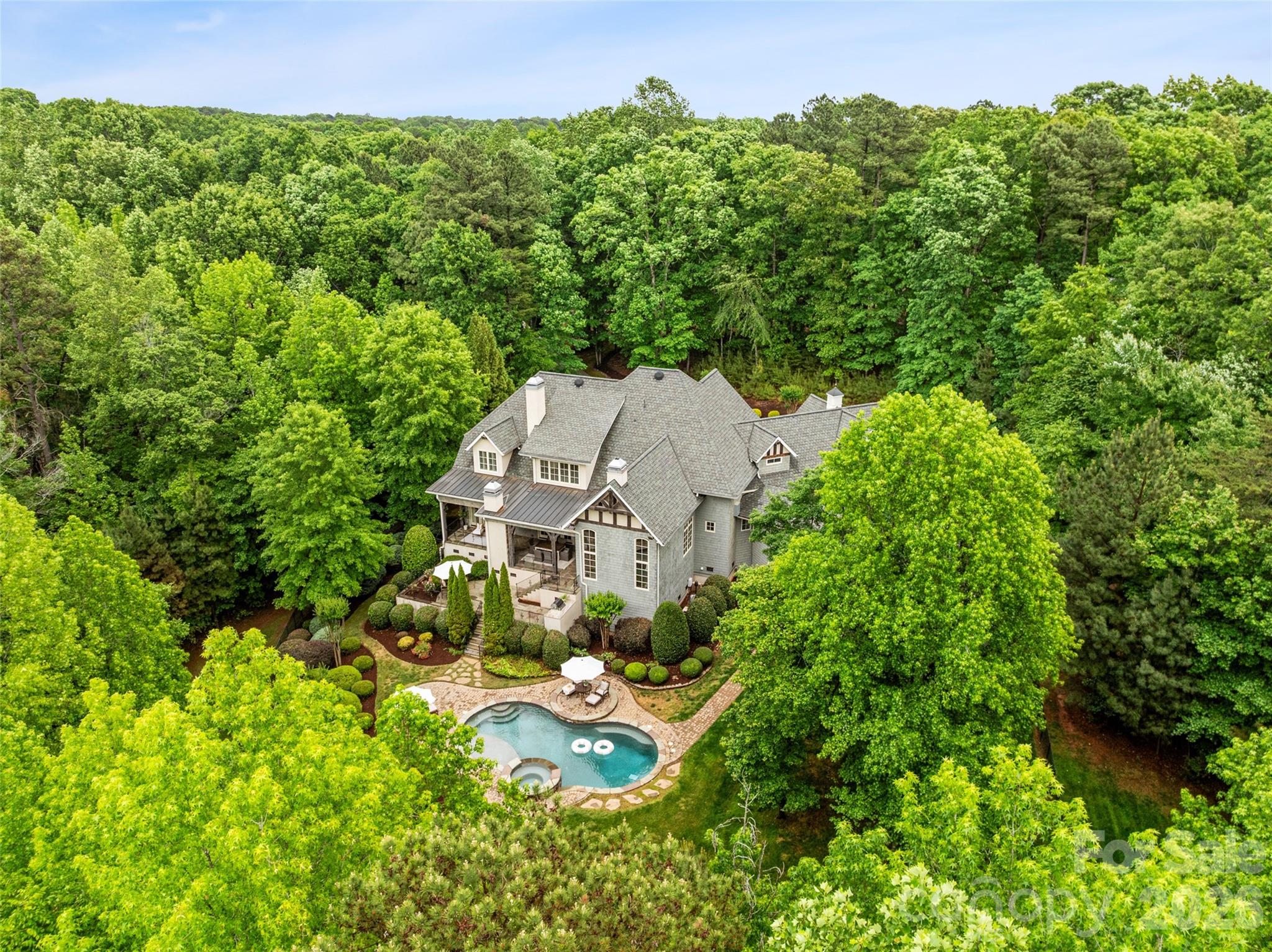 Tucked within The Sanctuary, a lakefront community on Lake Wylie known for its preserved landscape and natural surroundings, this custom-built residence offers a rare combination of scale, privacy, and everyday livability. Set on over six acres, the property is surrounded by mature trees, creating a sense of seclusion while still remaining convenient to Charlotte. A main-level primary suite and residential elevator provide ease of access across both levels, supporting a wide range of living needs. The home features three gas fireplaces, including a grand stone fireplace in the great room, along with refined interior spaces designed for both everyday living and entertaining. Upstairs, a sound-insulated media room creates a dedicated space for entertainment, along with additional bedrooms and a spacious suite featuring built-ins with a desk, sitting area, and a wet bar. The expanded wing is designed to support an active lifestyle, featuring an extensive gym with soaring ceilings, mirrored walls, and performance flooring to support a wide range of uses and the ability to create a fully equipped training environment. The space opens to the outdoors and includes a kitchenette and bar with a pass-through window that serves the poolside entertaining area. This addition also incorporates interior pool lockers and a full bath with shower, easily accessed from both the gym and pool.

The exterior living spaces are thoughtfully designed, centered around a two-level covered veranda overlooking a heated saltwater pool and spa, complemented by professional landscaping and a full-yard irrigation system.

Additional features include whole-house water filtration, central vacuum, integrated sound, in-floor heating in the primary bath, a 22kW natural gas generator, and EV charging.

Residents of The Sanctuary enjoy access to Lake Wylie, miles of private trails, tennis and pickleball courts, along with a community pool, splash pad, play area, and additional amenity spaces, all designed to support both recreation and connection.

A home of this scale, setting, and level of detail is best experienced in person. Private showings are encouraged.