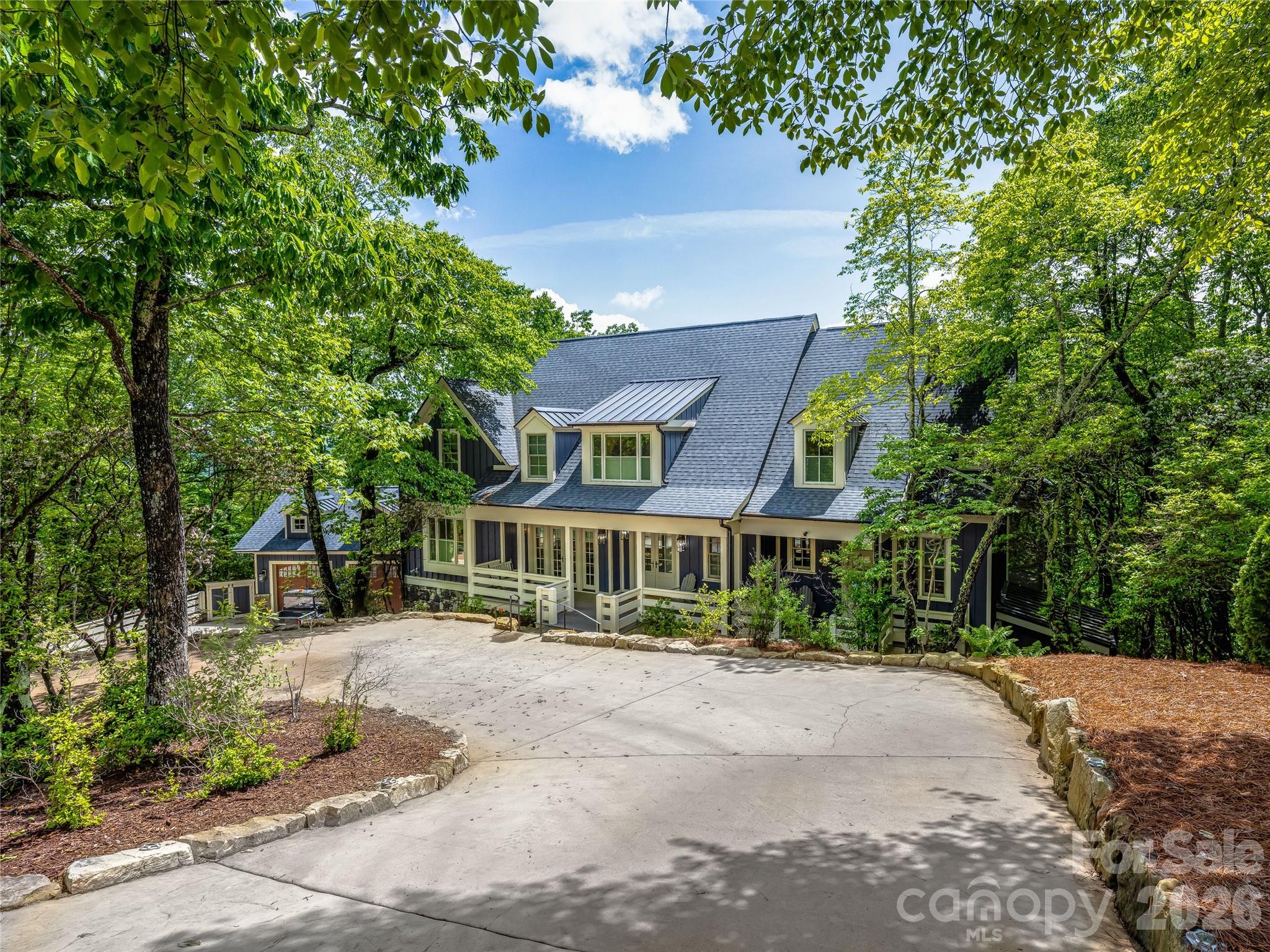 Positioned along the first ridge of Toxaway Mountain within the prestigious Lake Toxaway Estates, this extraordinary 5,000 sq ft mountain retreat blends timeless character with thoughtfully curated modern luxury. Once featured in Southern Accents as “a broad, low ramble of porches,” the fully renovated residence captures sweeping Blue Ridge Mountain views while offering exceptional privacy just minutes from Lake Toxaway Country Club and less than an hour from vibrant Asheville.
Designed for both relaxed mountain living and effortless entertaining, the home features 3 bedrooms, 6 bathrooms, and a beautifully reimagined open floor plan where rustic elegance meets refined comfort. A chef’s kitchen, spa-inspired baths, expansive gathering spaces, and thoughtfully designed interiors create a warm yet elevated atmosphere throughout. Multiple porches and patios embrace the surrounding mountain scenery, while a hidden children’s bunk room and flexible recreation space add charm and versatility for hosting family and guests alike.
Extensive improvements include a newly constructed 2-car garage with workshop, whole-house generator, UV water filtration system, EV wiring, and integrated smart home technology. Residents enjoy access to the exceptional lifestyle of Lake Toxaway, including scenic hiking trails, North Carolina’s largest private lake, and optional membership opportunities at Lake Toxaway Country Club based on application and availability. A rare offering designed to be enjoyed for generations to come.