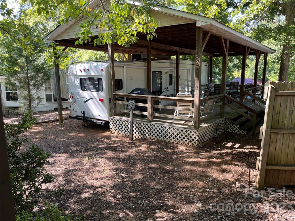 NEW PRICE! Enjoy Lake Tillery lifestyle without breaking the bank! 34' Holiday Rambler Alumascape Fifth Wheel crafted for long-lasting durability, stored safely under shelter throughout its life. Maintained by a single-family owner, this RV has minimal usage and remains spotlessly clean. On a shaded, paved, cul-de-sac lot walking distance to the swim beach. Covered deck runs entire length of home so ample space for social gatherings. Two slide outs and five cargo bays for storage. Accommodates up to 6 people with a sofa and dinette that can be converted into beds. Rear kitchen with dual sinks and genuine oak cabinets. Bathroom has glass shower enclosure and wardrobe/linen storage. Queen-sized bed, spacious closet, built-in desk. RV comes fully furnished, ensuring a hassle-free move-in experience. Electric heat/AC with auxiliary propane. Activities & amenities include pool, beach, horseshoe pits, playgrounds, variety store, tennis, basketball & more. Real estate agent required to access