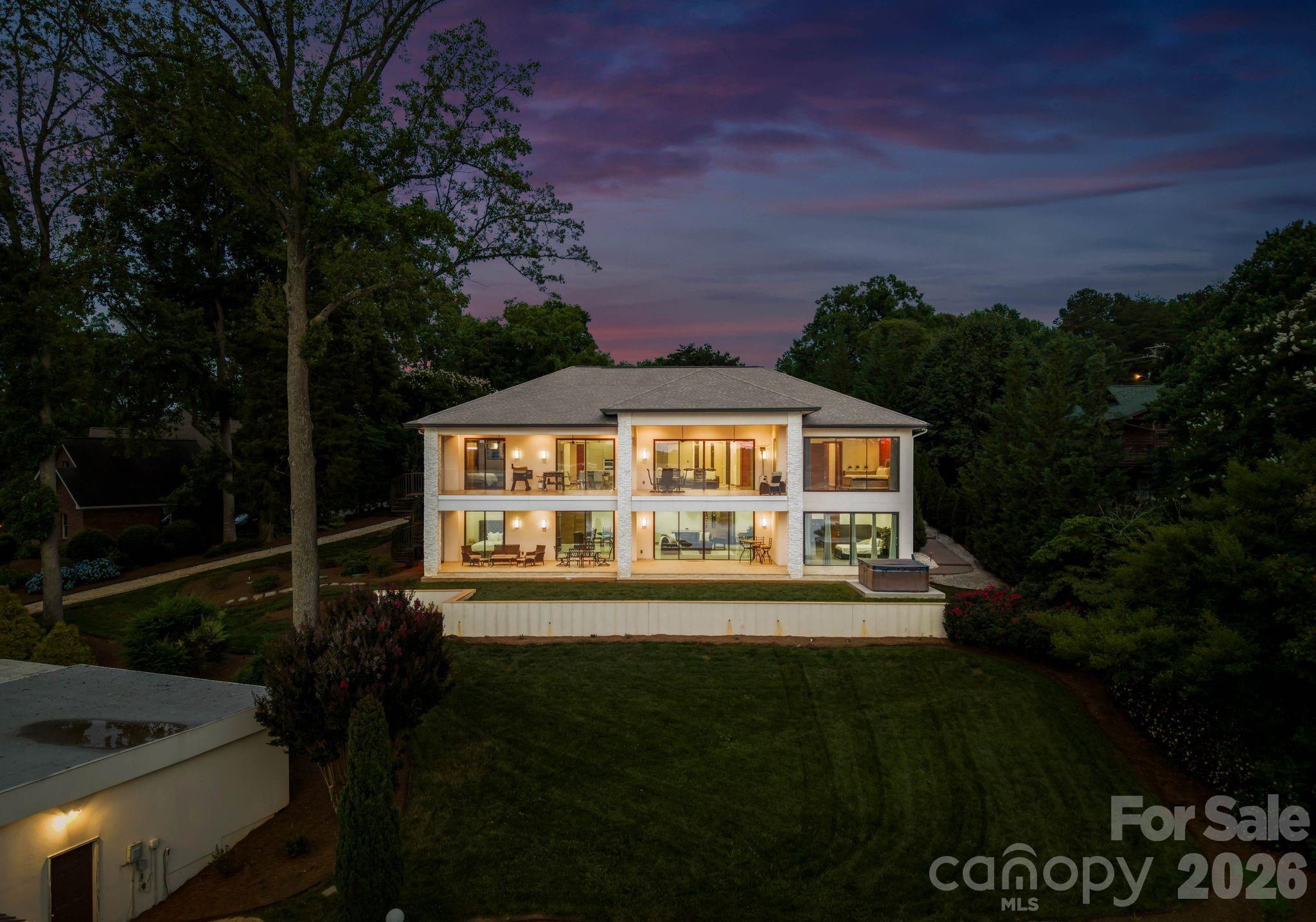 This is what you move to Lake Norman for.

The craftsmanship is immediate. Every surface, every detail, every finish was chosen with intention, and it shows the moment you walk in and see unobstructed water views. 

A Miele kitchen. An en suite bathroom in every bedroom. A split floorplan that gives everyone their own world. And a walkout basement that puts your two-tiered yard right at your fingertips.  Inside to outside without a single extra step.

The glass wall in the primary bedroom frames the sunset like a painting you never have to take down. Glass railings, a private cinema, sauna, and wine cellar round out a home designed for people who don't compromise.

Outside, the water does the rest. Deep water. Year-round views.  A covered dock with a grandfathered two-stall boathouse with ramp is a rare find on this lake (one stall currently used as a gym with a split system installed.)
There is no comparable. No substitute.