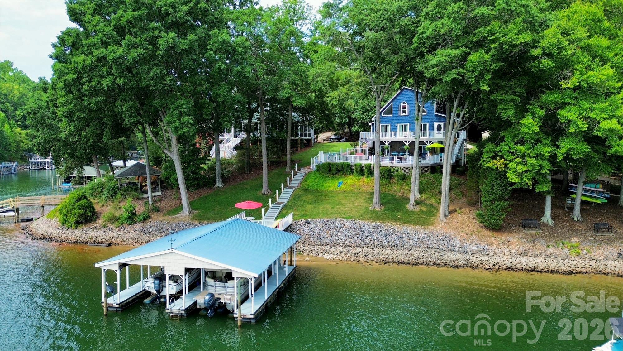 Experience lakefront living at its finest in this beautifully furnished waterfront home on the open waters of Lake Norman. Situated on a private, gently sloping lot along the desirable northern shores of the lake, this exceptional property offers breathtaking main-channel views and an ideal setting for relaxation and entertaining.

The outdoor living spaces are truly unmatched, featuring a spacious pool area with seating for up to 25 guests overlooking the lake, as well as a lakeside deck perfect for enjoying spectacular sunsets and waterfront gatherings. A double dock with boat lifts provides convenient access to the water for boating, fishing, and all your favorite lake activities.

Designed for comfort and flexibility, the home offers two separate living levels, each complete with its own full kitchen and bathroom, making it ideal for multi-generational living, hosting guests, or vacation rentals.

Whether you're searching for a primary residence, weekend retreat, or investment opportunity, this Lake Norman property delivers the perfect combination of privacy, luxury, and panoramic waterfront views.

Lake Norman Woods Neighborhood information is all available to download here: http://www.lakenormanwoods.com and click on the red HERE to access/download all HOA documents.