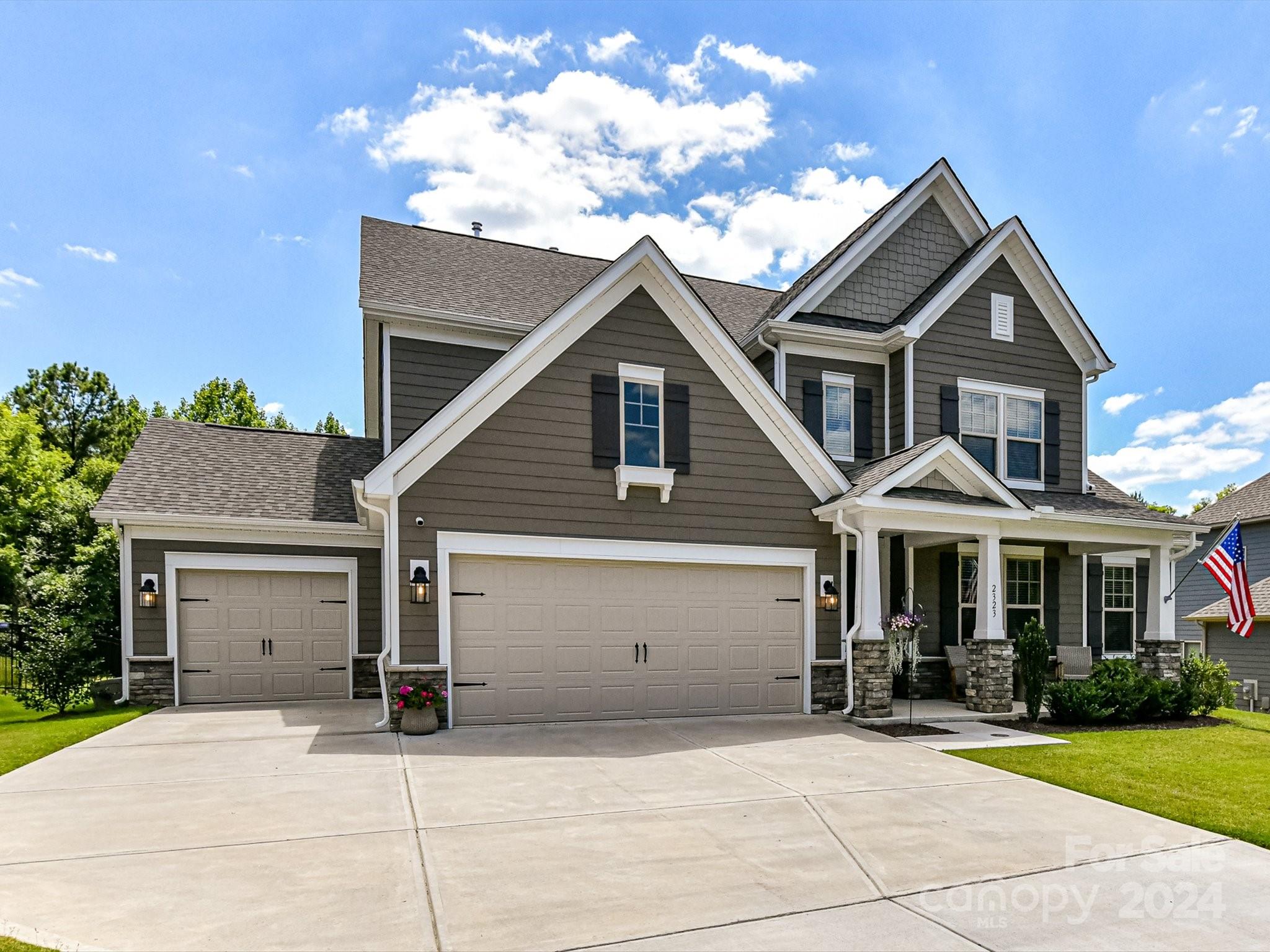 This charming Craftsman-style home spans 2 stories and features a spacious 3-car garage. The great room impresses with its elegant tray ceiling and a cozy 36” gas fireplace. The kitchen is a chef’s delight with white cabinets, quartz countertops, an apron front sink, a large walk-in pantry, a 36” gas range, and an oversized island perfect for gatherings. Conveniently located off the garage entry, the drop zone leads into the laundry room. The first-floor owner’s suite includes a tray ceiling, a soaking tub, a frameless glass shower, dual sinks, and a generously sized walk-in closet. Upstairs features three additional bedrooms with access to two full baths. A spacious bonus room offers flexibility for various activities. Office with French doors provides privacy for work or study. Finishing touches such as designer lighting and Mohawk laminate wood floors add to the home’s character. Abundant windows fill the interior with natural light. Large, fenced backyard; backs to the woods.