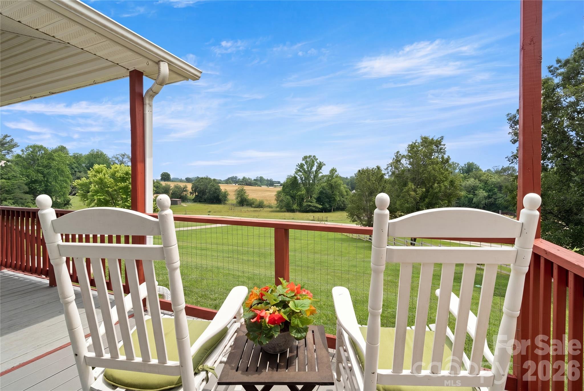 Discover a little slice of heaven nestled in the heart of apple country. From the practically perfect panoramic views to the blissful breezes blanketing the surrounding rolling pasturelands, this setting cannot be beat. Journey down a well-kept lane through a cops of trees standing sentry along a meandering stream then opening up to a wide, glorious sky over an oasis that is the home you never dreamt could be yours. While Countryside is set apart from the busy bustling business of the world, it is by no means isolated. It’s only 15 minutes to the charm of the historic downtowns of Hendersonville or Flat Rock. 10 minutes gets you to the boulevards providing all the major conveniences as well as to the highway heading North to Asheville or South to Greenville/Spartanburg in under an hour.  Close by are numerous expansive parks including the Oklawaha Greenway.
Coming home after a busy day, you get to unwind on the South-facing front porch, letting time slow down around you. Listen to the symphony of birdsong or the gentle patter of rainfall. The back deck is perfect for grilling while taking in the simple pleasure of seeing the wind ripple the grass in the fields stretching out behind your home. Further, appreciate the rare gift of both sunrises AND sunsets from indoors or outdoors. Across the lane, horses graze peacefully in a picturesque landscape that transforms with the seasons: flowering trees in spring, all shades of green in summer, autumn finds migrating geese and ducks just overhead, and crisp winter vistas reveal a distant country church steeple beyond a patchwork of field and farmland. 
It gets even better on entering the home.  Abundant large windows and glass doors throughout flood the interior with natural light and act as picture frames that bring the outdoors inside. The open-concept living area and large kitchen adjacent to the back deck and grill offer a welcoming environment perfect for entertaining or a relaxed activity. The private quarters are arranged in a split floorplan with laundry/utility, two bedrooms, two ensuite bathrooms AND a bonus room on one side; while on the other, double doors open to a huge, to-die-for primary suite boasting provision for a kitchenette including dedicated wiring, one and a half baths, an enormous walk-THROUGH closet, and a beautiful sliding glass door providing a separate, private entrance that steps out from the Primary Suite to a Trex deck, which extends off the front porch, and gives easy access to the side yard via a ramp. There are multiple options for this suite: personal retreat, in-law suite, attached nursery, guest quarters, income-generating opportunity on-site, you decide.
Yes, the pictures are great…BUT it is even more enchanting in person. This home was cared for by the previous owners and even more meticulously maintained and improved by the current. Recent installations from previous owners, include architectural roof (2022), HVAC (2024), and water heater (2024).
Current owners added a custom CPI security system including a remote access thermostat, and extra outside camera’s (can be transferred to the new owners for just the monthly fees), LVP flooring (2025), interior and exterior paint (2025-2026), keypad entries (2025), upgrades at the well head (new pressure system (2025), risers on the septic (2025), a whole house 3 stage water filter to filter out sediment and forever chemicals, and a reverse osmosis water filter under the kitchen sink, for drinking and cooking (2026). new 10-yr battery smoke detectors (2026). And there’s more. Ask to see the complete list of improvements in the MLS attachments. A home like this? In a location like this? At this price? Yes, really! Don’t miss your chance to make this rare gem yours. Come experience it for yourself today!