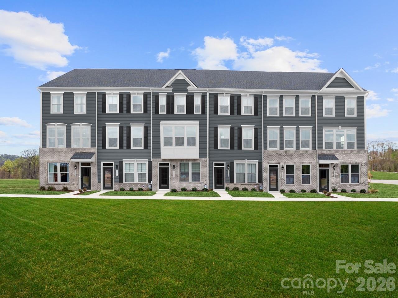 Welcome to Ashmore Square, a modern townhome community in Charlotte’s thriving Research Park District, ideally positioned near UNC Charlotte, the Vanguard Campus, and TIAA. Located less than 2 miles from I-85, this community offers quick access to Uptown Charlotte, University City, and major commuter routes. Everyday convenience and entertainment are just minutes away with IKEA, Topgolf, shopping centers, dining options, and nearby greenways all within close reach. Ashmore Square blends architectural style with low-maintenance living, featuring attractive brick and fiber cement exteriors, sidewalks, and a welcoming central courtyard designed for gathering or relaxing outdoors. HOA-managed lawn maintenance allows residents to enjoy community spaces without the burden of exterior upkeep. The neighborhood offers the ideal combination of connectivity, convenience, and modern appeal. This end unit Clarendon floorplan delivers a flexible three-story layout with additional end unit windows is designed to support a variety of lifestyles. The lower level includes a private bedroom with a full bath, ideal for guests, a home office, or additional living space. The main level features an open-concept kitchen with under cabinet lighting and breakfast bar that flows seamlessly into the dining area and family room, creating an inviting environment for entertaining or everyday living. Upstairs, the owner’s suite includes a walk-in closet and ensuite bath with a frameless shower door, complemented by an additional bedroom and conveniently located laundry. Buyers may take advantage of closing cost assistance when using the preferred lender. Experience modern townhome living in one of Charlotte’s most connected locations—schedule your visit today to learn more about Ashmore Square and the Clarendon floorplan.