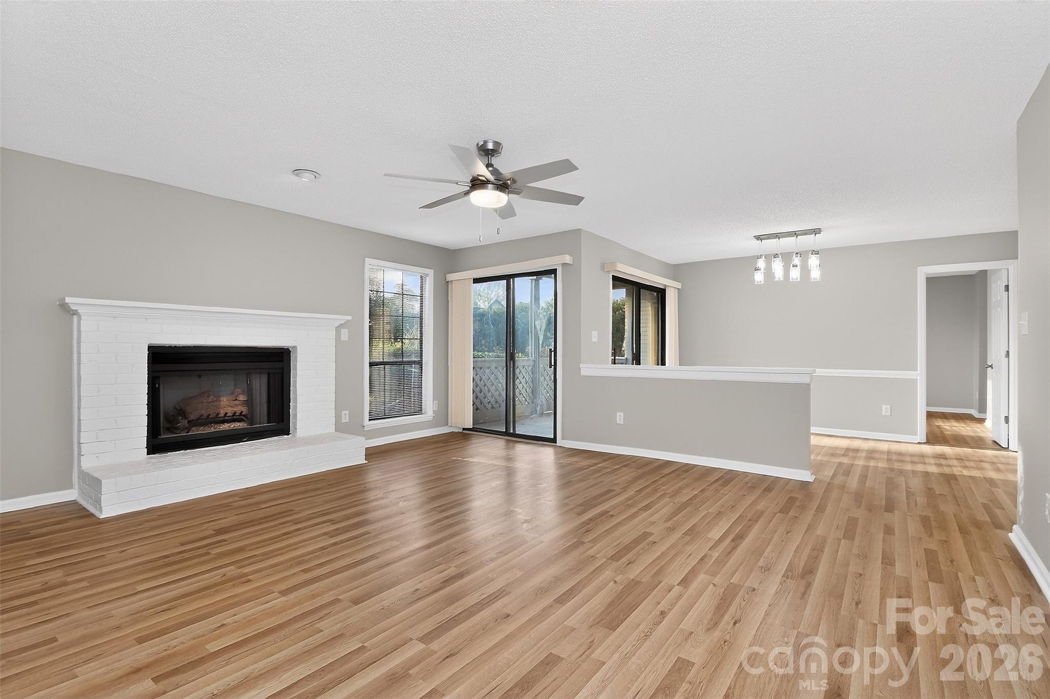 Welcome Home to this beautifully renovated ground-level 2-bedroom, 2-bath condo in the well established Harris Lake Community. Step inside to find fresh paint throughout, new vinyl laminate flooring in the main living areas and master bedroom, and new carpet in the guest bedroom. The spacious open floor plan features a cozy brick fireplace, a new chandelier in the dining area, and modern lighting and ceiling fans in every room. The kitchen has been completely updated with slow-close cabinets, granite countertops, a subway tile backsplash, brushed nickel fixtures, and stainless steel appliances. Both bathrooms have been tastefully remodeled. The hall bath features floor-to-ceiling tile, a new vanity, laminate flooring, and updated fixtures. The custom master bath boasts a large garden tub, new tile with niche, and modern lighting and hardware. Additional updates include all new door hardware and a brand new A/C system (interior and exterior) installed March 2026. Enjoy two storage rooms—one on the balcony and one at the front of the unit. Relax on your private deck and let in natural light through the large windows and sliding doors. The community recently had new roofs and exterior updates completed by the HOA. Conveniently located near Uptown, the Airport, Plaza Midwood, and NoDa, this condo offers both comfort and accessibility. Similar Condo closed at 223,500 MLS 4330837 without new AC System. No rental cap (Airbnb not permitted). Spacious layout, upgraded finishes, and modern style throughout—this one is a must-see with instant equity! FHA Eligible June 10, 2026.