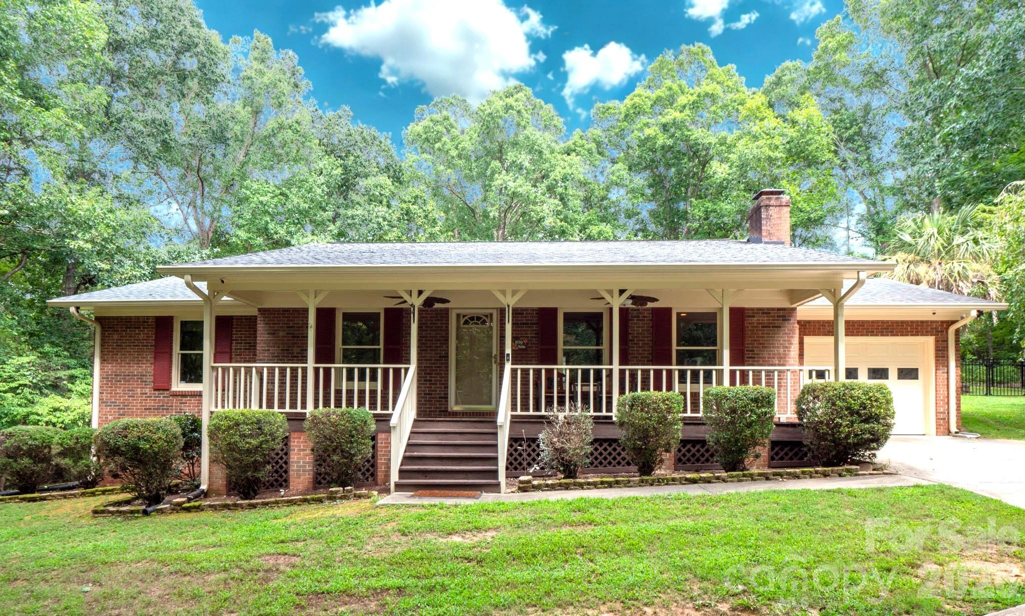 Private wooded retreat on 2 acres — ranch living with no HOA. Impeccably maintained and thoughtfully updated, this single-level home sits tucked into mature trees for total privacy and peaceful, resort-like outdoor living. The backyard features an inground pool oasis surrounded by nature, perfect for relaxing or entertaining. Inside, an open, spacious kitchen is ideal for gatherings and everyday living. Practical comforts include a whole-house water filtration system and an outbuilding/workshop with a climate-controlled mini-split — great for hobbies or storage. Enjoy the rare blend of seclusion and convenience: minutes to Hwy 601, I-485, Monroe, and Charlotte, with low Union County taxes. A hidden gem ready to enjoy.