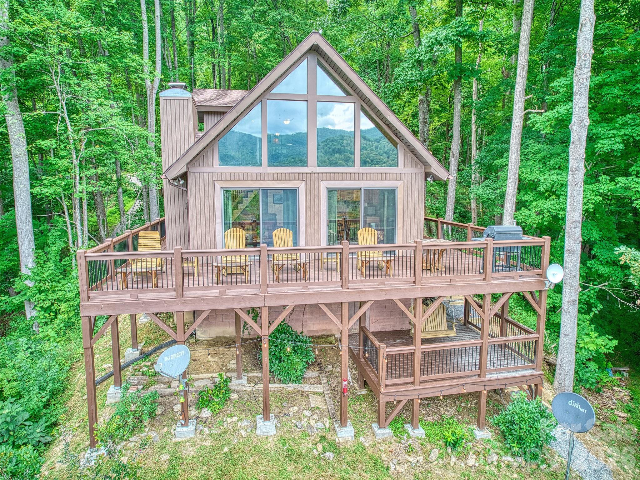 Make this dreamy A-frame cabin your own private mountain retreat, a money-making Airbnb, or your full-time escape into the peaceful beauty of the Blue Ridge! Take in incredible year-round mountain views from inside or out thanks to the massive windows that flood the space with natural light and bring the outdoors in. Enjoy cool evenings by the wood-burning fireplace, stargaze from the wraparound deck, or gather around the fire pit for mountain memories. Inside, you’ll love the modern touches including granite countertops throughout, stainless steel appliances, and a walk-in shower in the open loft-style primary suite. A large storage shed gives you plenty of space for gear and supplies. Whether you're looking for a getaway that pays for itself or a peaceful place to call home, this cabin is mountain living at its best.