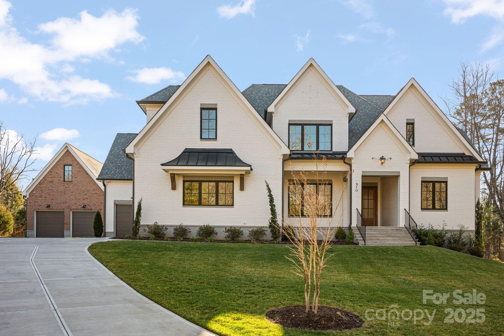 A meticulously crafted masterpiece spanning 4,643 square feet of luxurious living space on a sprawling 1.75-acre lot, 810 Martingale Lane was completed in 2024 and seamlessly blends modern design with timeless elegance. The open-concept floor plan features high ceilings and an abundance of natural light. The gourmet kitchen boasts top-of-the-line appliances and custom cabinetry, while the luxurious primary suite offers a spa-like bathroom and spacious walk-in closet. In addition to the attached 3-car garage, a 900 sqft detached garage provides ample space for vehicles, storage, a workshop, rec room or future pool house. The expansive lot is ideal for hosting gatherings, creating a garden oasis, or simply enjoying the peaceful surroundings. Situated in a tranquil, sought-after area of Davidson, this home offers the perfect combination of privacy and convenience. Don't miss the opportunity to make this exceptional property yours.