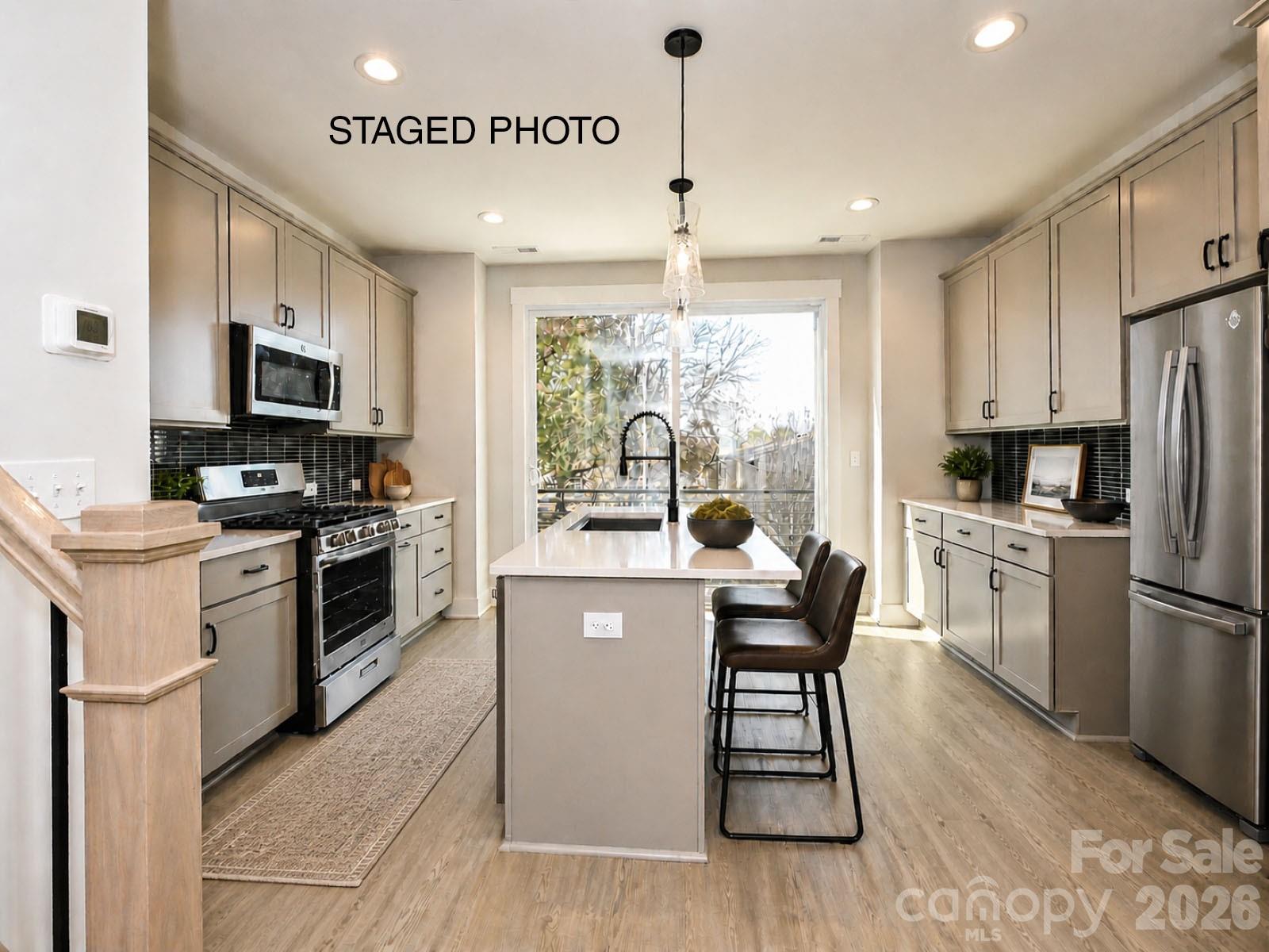4-story townhome with a fantastic location w/ seasonal views of Uptown Charlotte from the front terrace; walk to Camp North End. Highlights include 9' ceilings, a 1-car attached garage plus driveway, on-trend lighting & design features, & a 1st floor flex r00m w/ powder. Easily entertain on the 4th floor with the Bed/Bonus Room & spacious rooftop terrace. Open layout on the second floor. Kitchen features 42" cabs w/ matte black hardware, pantry cabinet, trash pullout, LED under-cab lights, quartz counters, large SS undermount sink, & GE SS app w/ gas range. Small deck off the kitchen. 3rd floor has both bedrooms, laundry closet & hall bath. Full baths have quartz counters, tile floors. Premier Suite has a tiled shower w/ semi-frameless enclosure & matte black hardware. LVP flooring is throughout 1st & 2nd floors, plus 3rd  floor hall. Oak treads are on all stairs.