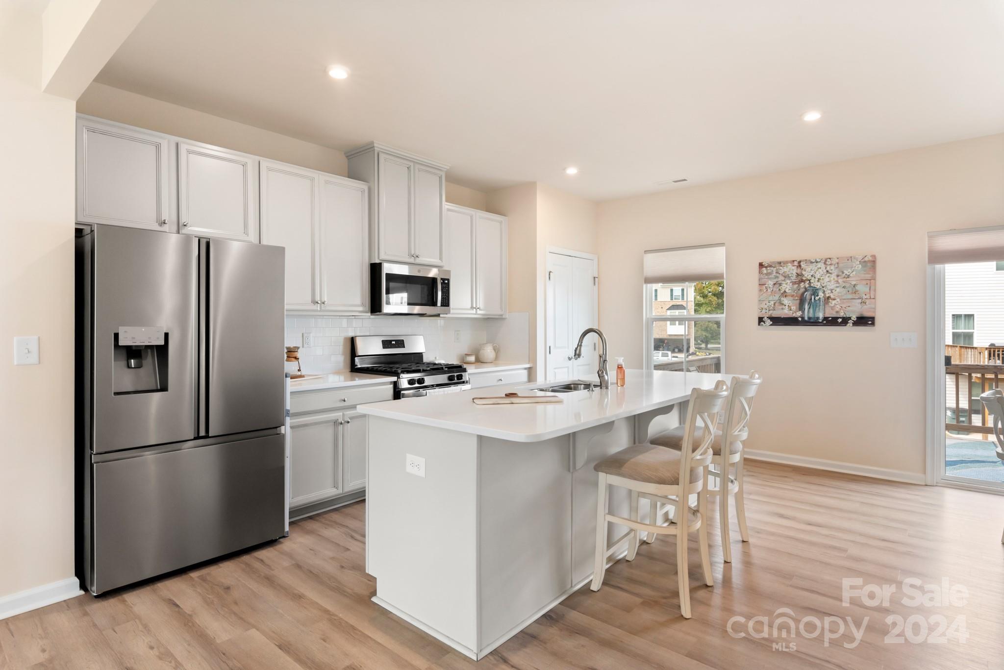 Premium END UNIT townhome adjacent to a large common area, on a cul-de-sac, AND zoned to Award Winning Fort Mill Schools! Built in 2021 this home has been meticulously maintained and hardly lived in! BRIGHT white kitchen with large island for cooking and entertaining, separate dining area, and large gathering space make this townhome live like a single family home! Balcony off the kitchen and additional windows provide plenty of natural light! Light colored and durable LVP floors throughout the main living space and upgraded hardwoods on the stairs! Third level with three bedrooms, two full baths, and laundry room. Lower level recreational room with multiple uses and access to a covered, private patio.  Two car garage with its own AC unit beautifully cools the garage and the finished walls/floors make it ready for multiple uses - a workout room, additional living space, or even an art studio! Tucked away in a quiet neighborhood and next to the walking trails, yet quick access to I-77!
