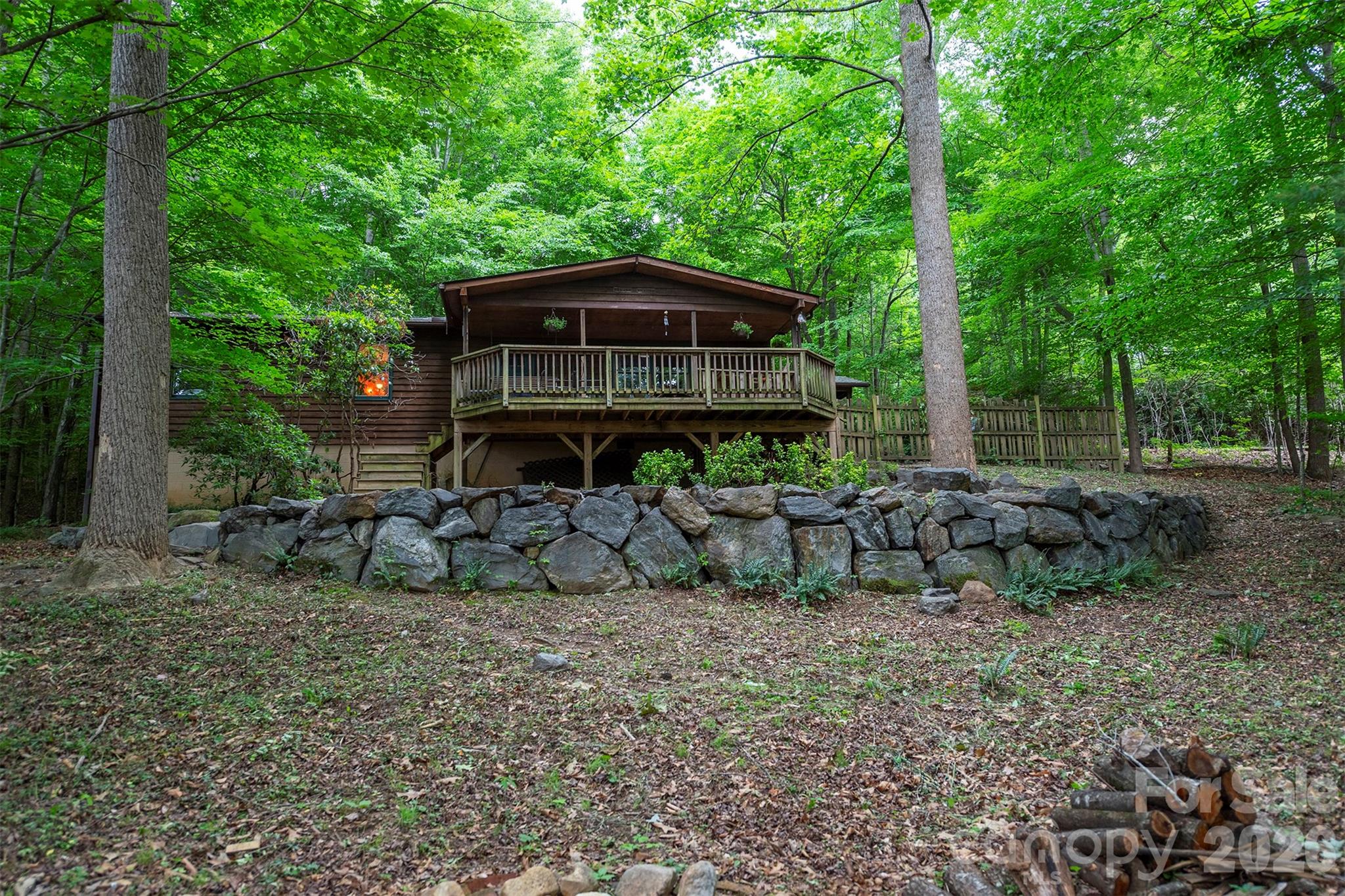 Come see this charming mountain retreat on a private acre of wooded land that’s rich with wildlife and rustic, timeless character. Just minutes to downtown Black Mountain and only 15 minutes to Asheville, this 3BR/2BA home offers a tranquil natural setting with seasonal mountain views. Inside, some of the highlights include a cozy wood-burning stove, hardwood and tile floors, a spacious great room, a recently renovated kitchen, and a primary bedroom with its own private deck access. Wake up to birdsong and then head on outside to sip your morning coffee while watching playful squirrels and abundant wildlife. In the evenings, unwind by watching the fireflies from the expansive front or rear deck— both are ideal for entertaining or simply relaxing in the peaceful and private mountain setting. Additional highlights include a carport with workshop, additional storage building, ample parking, and short-term rental potential (buyer to confirm). Major updates include a 2020 central HVAC, a 2020 water heater, and a 2017 roof. A rare opportunity to enjoy privacy, convenience, and mountain charm all in one property.