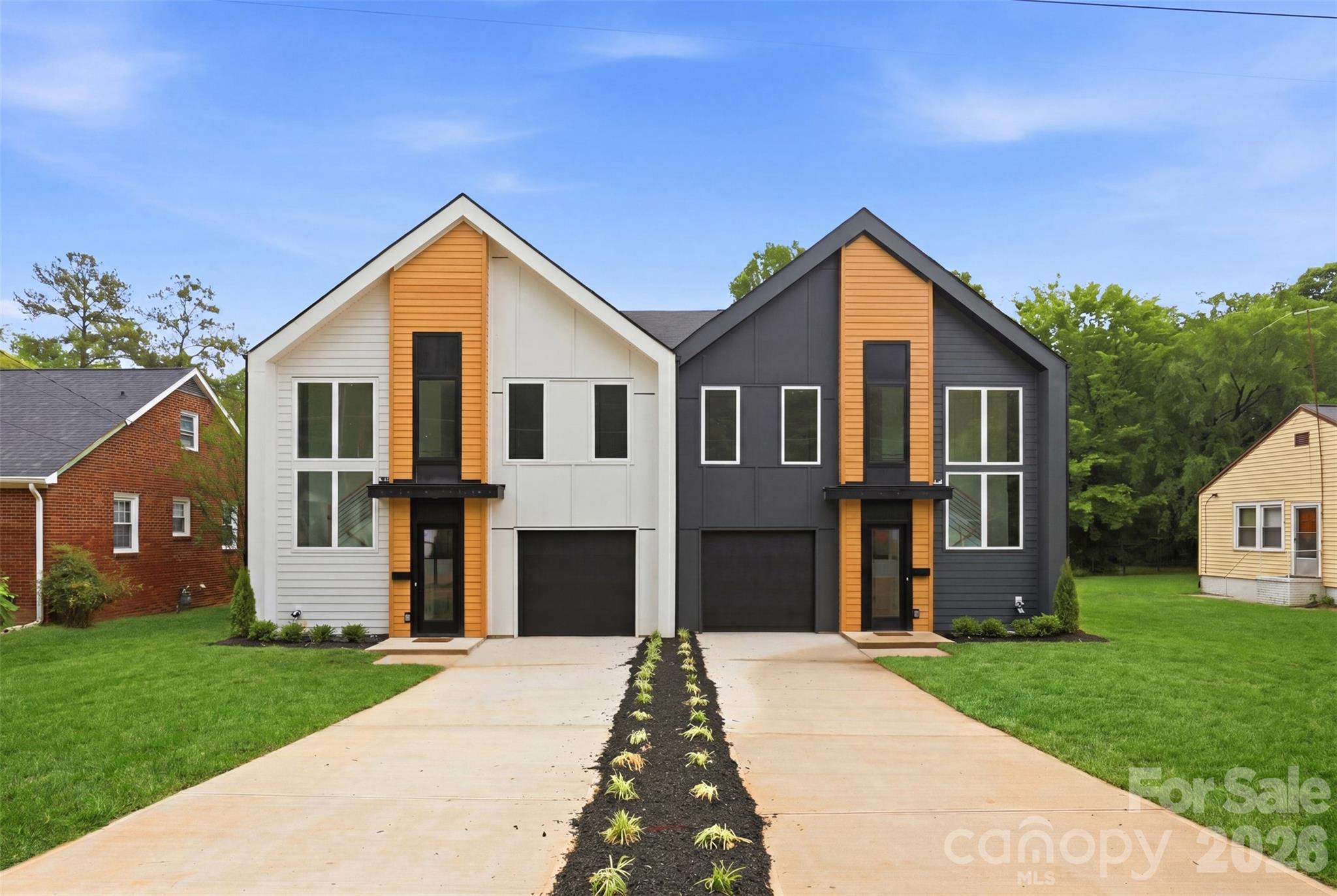 Just steps from the electric energy of Camp North End, this stunning new construction townhome delivers the perfect blend of modern architecture, thoughtful design, and unbeatable urban lifestyle. The bold dual-tone exterior with warm cedar accents and dramatic black garage door sets the tone for everything inside. Natural light floods every corner through oversized windows throughout, highlighting the open-concept floor plan that flows seamlessly from the foyer through the living, dining, and kitchen. With 9-foot ceilings, gorgeous LVP flooring, designer lighting, and custom molding details demonstrate the intentional craftsmanship found at every turn. The chef's kitchen stuns with a large island, premium quartz Palisades Gold countertops, shaker cabinetry, open floating shelves, and stainless steel appliances — opening beautifully to both the dining and living areas. Upstairs, the primary suite is a true retreat featuring a soaring tray ceiling, oversized walk-in closet, and a breathtaking primary bath with dual vanities, large-format designer tile, and a frameless glass walk-in shower. Two additional bedrooms, a dedicated office with built-in shelving, full laundry room, and a beautifully finished second bath complete the upper level.
