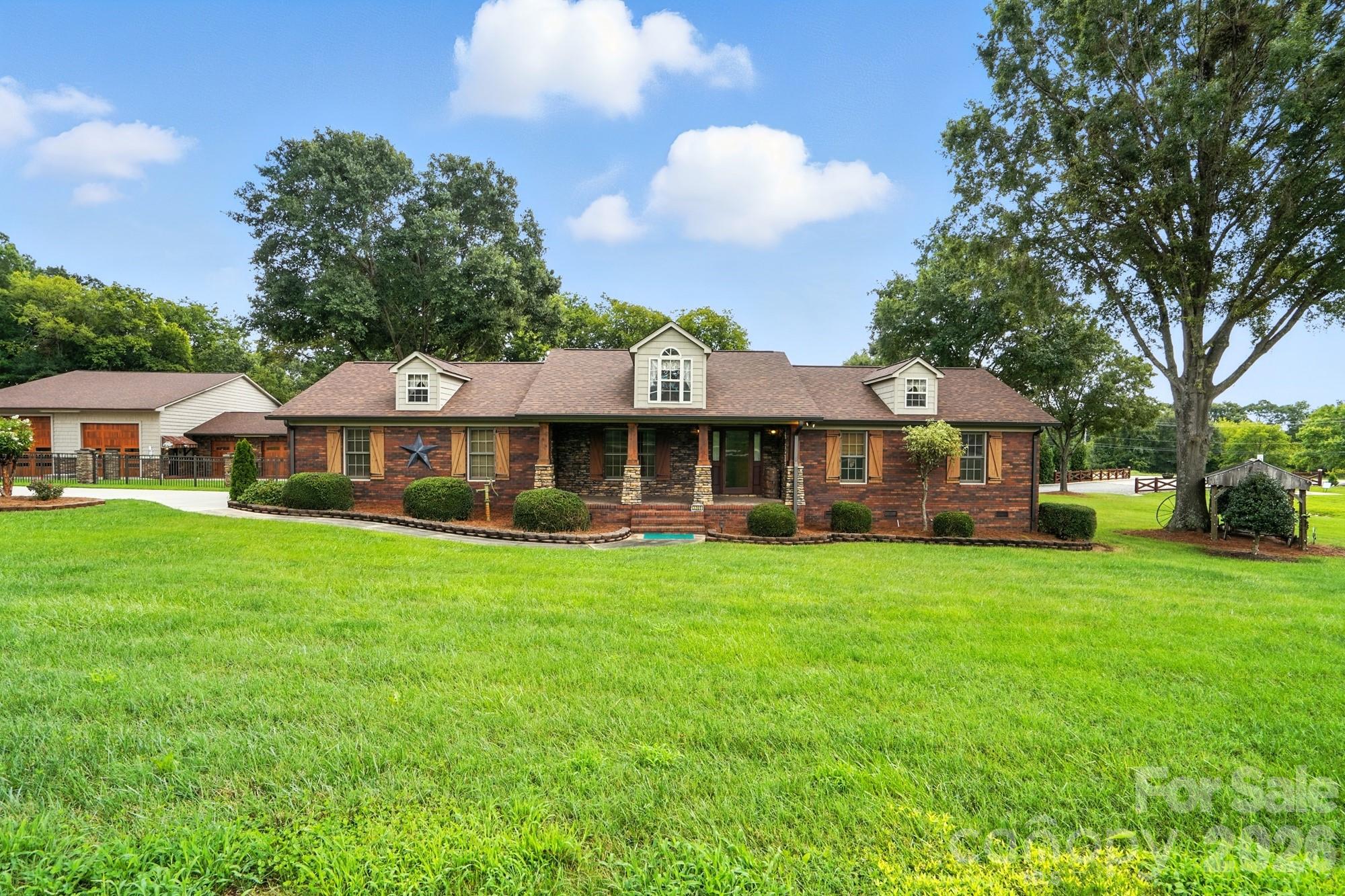 Discover this unique Concord property featuring a full-brick 2BR/2BA main home with lodge-style charm, hardwoods, tile, and stone accents. Enjoy the spacious covered front porch and an oversized back porch with fireplace and mounted TV. The fenced backyard offers a patio, gazebo, and a historic 1800s cabin relocated from downtown Concord. Car enthusiasts will love the expansive main garage with HVAC, office, half bath and lifts—plus room for 10+ vehicles, plus carport space. Sitting on 1.2 acres with no HOA, this property is ideal for those seeking versatile living and unmatched garage space.

Small carport in front of large garage shown in photos has been removed and will not convey.

Seller offers credit up to $1500 toward home warranty of the purchasers choice.