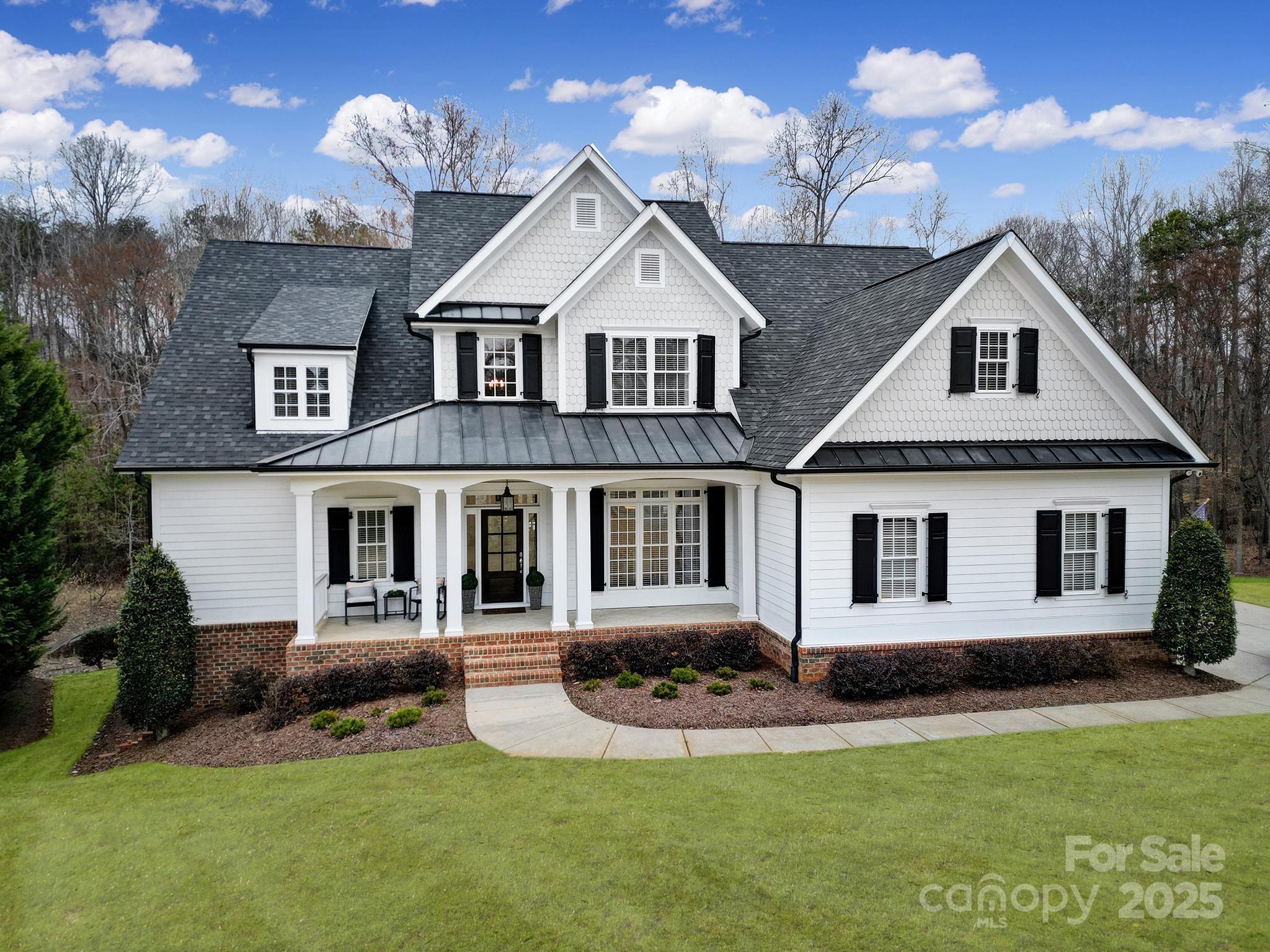 This quintessential southern charmer, located in the highly desired Springfield community is ready for it's new owner. From the moment you pull up to the home you'll be graced with a welcoming front porch. Inside you'll find a grand foyer, a formal dining room, large family room, open kitchen/living room, and spacious primary suite on the main. Upstairs you'll find 3 oversized BRs, 3 BAs and a 4th BR/Bonus room (with additional laundry hook up if you desire on the 2nd floor). After a long day you will love escaping to the peaceful private backyard w/ expansive deck and custom built woodburning fireplace. But wait, there's much more! Downstairs you'll find a finished walk-out basement that includes rec room, BR, BA, storage, gym (that would also make a great media room) and a 4th car garage/workshop! This home has it all- luxury, space, and prime location. Springfield offers tennis courts, 3 pools, pickle ball, playgrounds, walking trails and an Anne Springs Greenway membership.