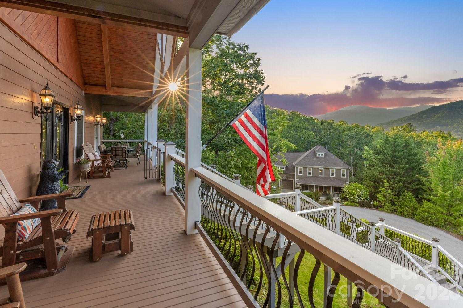 This Fairview retreat offers long-range mountain views, generous scale, and a private mountainside setting.
Set in a quiet neighborhood, the home captures sweeping northern views and offers a setting for long, unhurried evenings immersed in nature. A 72-foot rocking chair front porch spans the front of the home, showcasing panoramic mountain and valley views—ideal for morning coffee, reflection, or sunset.

Custom built with oversized appliances and upgraded systems, the home delivers comfort and longevity. Vaulted ceilings and expansive living areas create volume and light throughout. A massive imported marble fireplace anchors the main living space. The chef’s kitchen is designed for gathering and function. The flexible floor plan supports multi-generational living or entertaining, with three ensuite bedrooms and the option for a second living quarters with private entrance. A dedicated space provides options for a home office, studio, or workshop.

A screened-in porch/recreation room includes a hot tub for year-round enjoyment. The iron-fenced yard offers a secure outdoor space for pets. An elevator adds accessibility, while a whole-house generator delivers full-home power for extended periods. A 1,000-gallon propane system supports reliability and independence.

Located near Hickory Nut Gap Farm, local breweries, the Blue Ridge Parkway, and the Mountains-to-Sea Trail. Just 20 minutes to downtown Asheville, Black Mountain, and the AVL airport, offering access without sacrificing privacy.