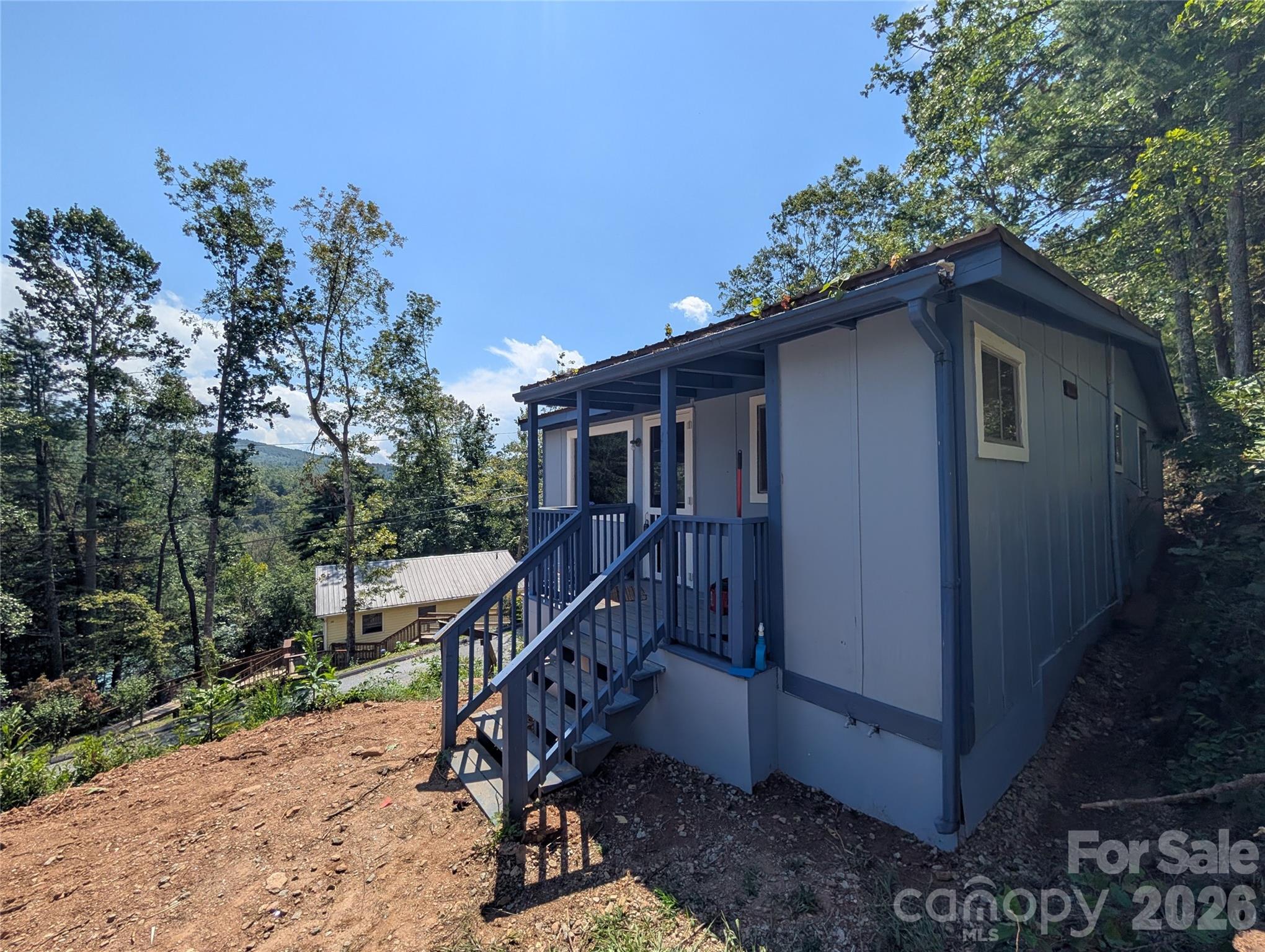 This could be your cabin in the mountains! This two bedroom one bathroom home has been recently painted on the exterior with updated flooring and bathroom fixtures. High ceilings in the living area with an open floor plan. Sit on the porch swing and enjoy the mountain air. Located in the peaceful McMillan Hidden Valley just 23 minutes from I-26 and shopping. New 2 bedroom septic tank and drainfield isntalled in August of 2025. ***Do Not Follow GPS to the home. It will get you to the neighborhood. Take the third Oak Ridge Rd access after you pass the home, not the first or second one. ***