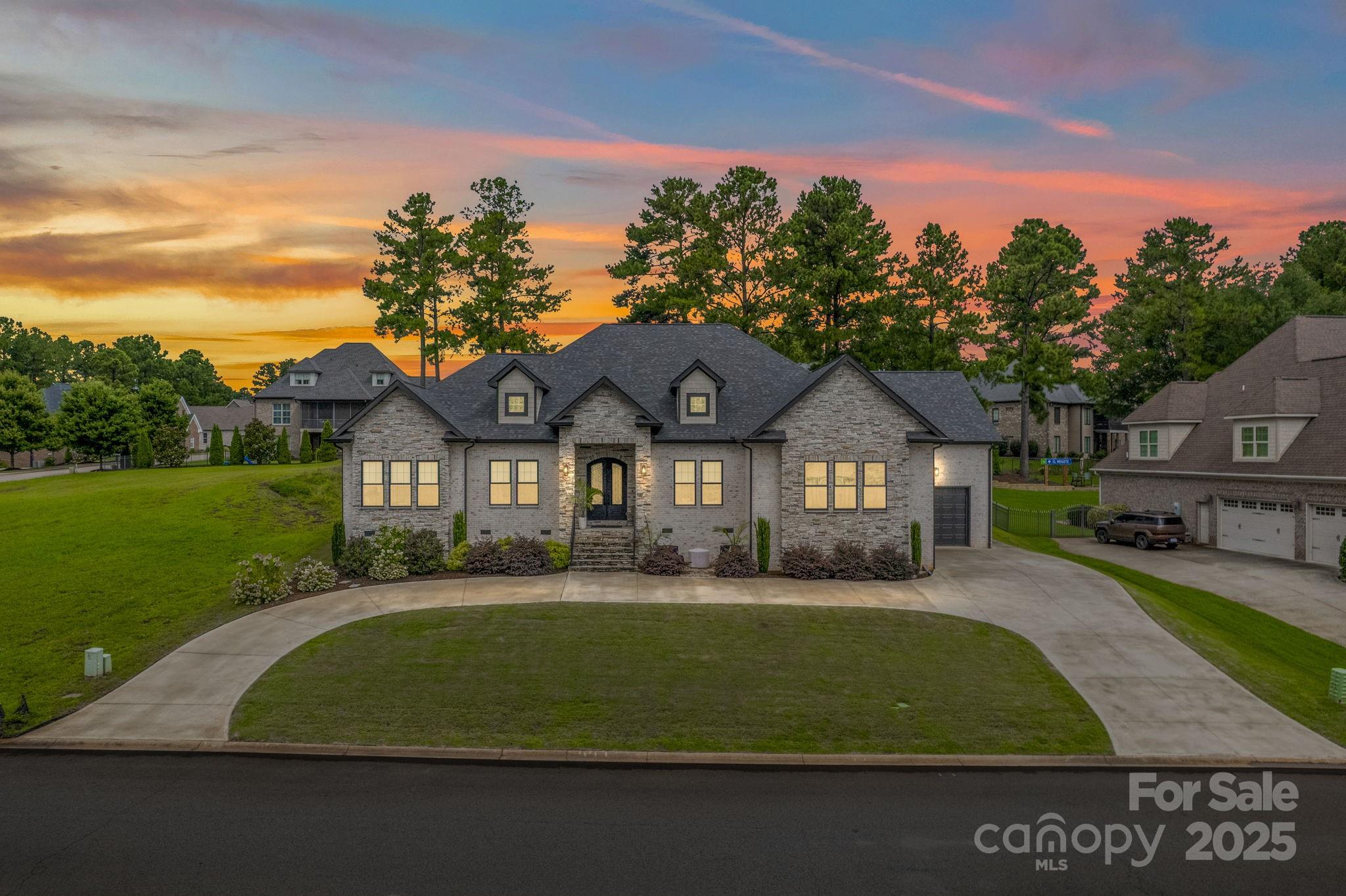 Built in 2022 and extensively upgraded, this 3300 sq ft 3 bd, 3.5 bath home with office/flex space in Woodfin Ridge offers luxury one level living. Iron double doors open to 12 foot ceilings, custom cabinetry and designer lighting. The open living area features a stone gas fireplace with oak built ins, expansive windows and sliding glass doors. The chef's kitchen boasts a quartz countertops, large island, 8 burner gas range w/ pot filler, double ovens, a hidden walk in pantry and soaring cabinetry. The primary suite has 2 lg. closets, a soaking tub and an oversized shower.  Sliding doors lead to a patio and your very own sauna with a full walk in shower offering you a dose of luxury and relaxation. The rear patio is wired and plumbed for an outdoor kitchen. Living in Woodfin Ridge means access to golf, a driving range, pickleball and so much more. Conveniently located to I-85 and I-26. This is more than a home, it is a lifestyle designed for comfort connection and everyday elegance.