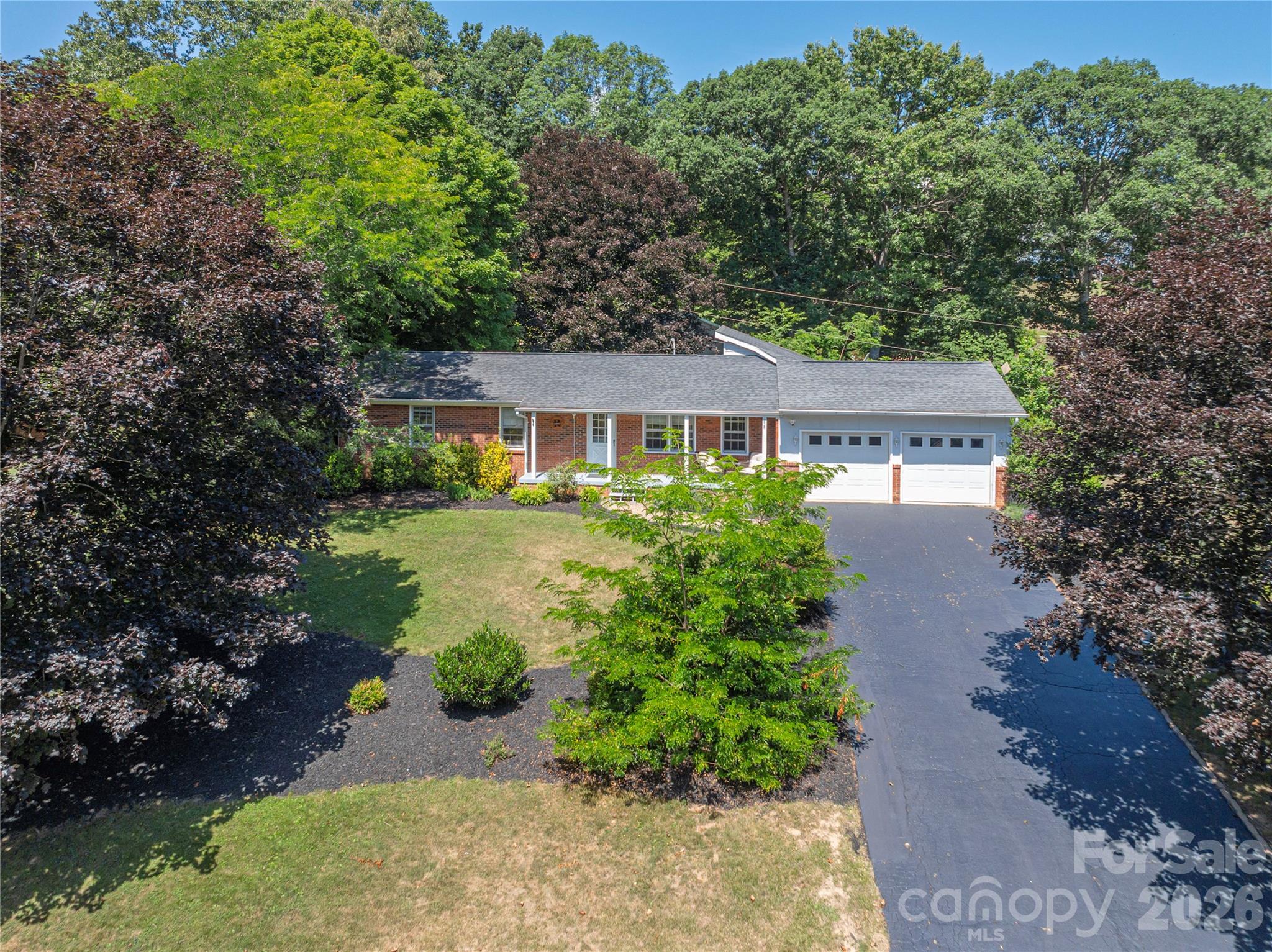 Welcome to this beautifully maintained ranch home nestled in the highly desirable Camelot Heights neighborhood. Thoughtfully designed for comfortable everyday living and effortless entertaining, this inviting home offers multiple gathering spaces, a centrally located kitchen with abundant cabinetry and pantry storage, and a bright sunroom overlooking the beautifully landscaped backyard. The welcoming family room features a custom wood accent wall and unique bar seating, creating the perfect space to gather with family and friends. Step outside and enjoy your own private outdoor retreat with an expansive deck, cozy stone patio, fire pit, and mature trees that provide both shade and privacy. Three generously sized bedrooms, two full bathrooms, and a two-car garage complete the home's functional layout. Conveniently located just minutes from downtown Waynesville, Lake Junaluska, shopping, dining, and medical facilities, this move-in-ready property offers the perfect combination of comfort, character, and convenience. Don't miss the opportunity to make this exceptional home yours.
