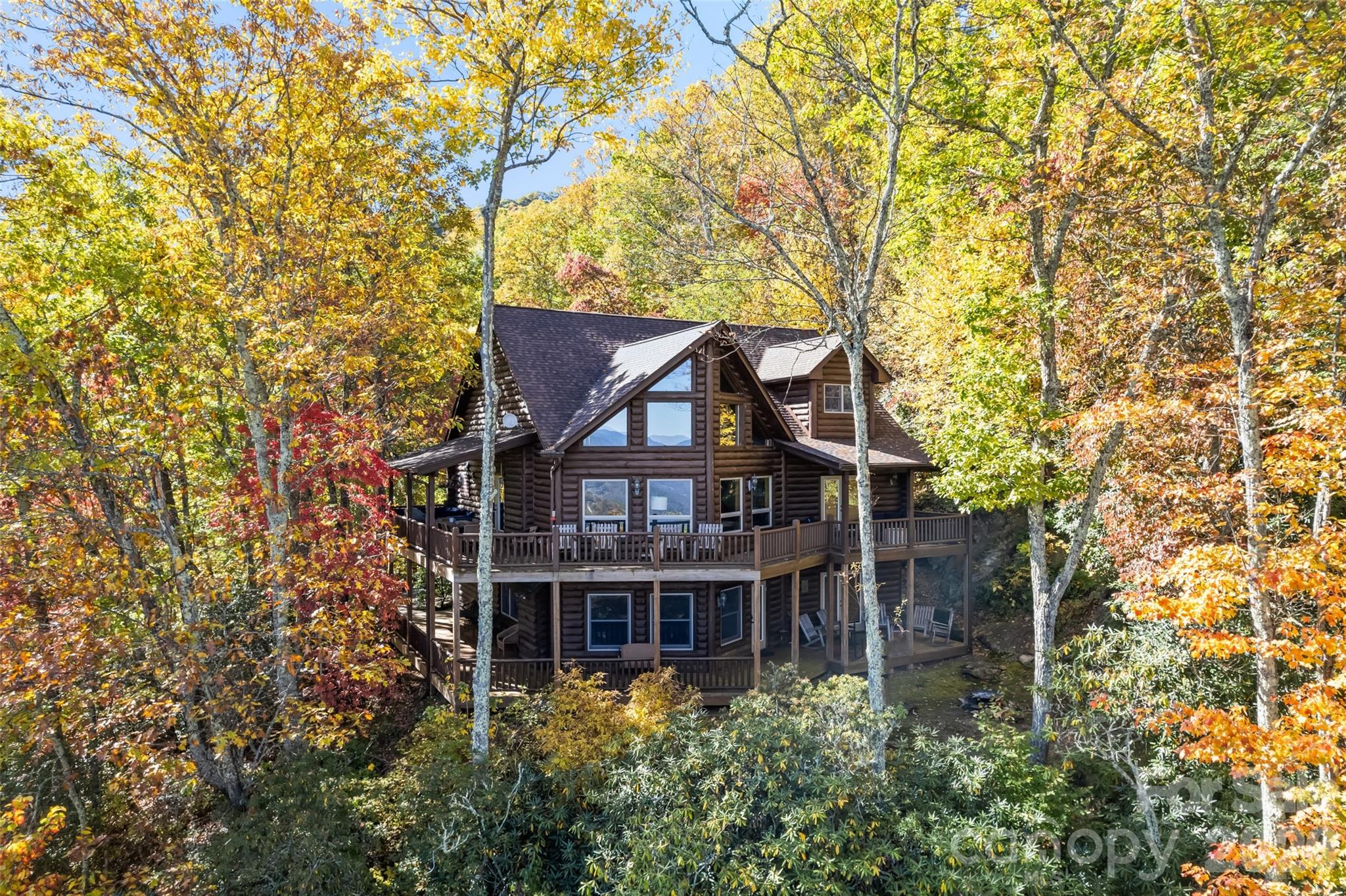 Discover mountain living at its finest in this beautifully appointed log cabin located in the sought-after Smoky Mountain Retreat at Eagle's Nest in Maggie Valley. Nestled at 3,840 feet elevation, this home offers stunning views of Jonathan Valley and the surrounding mountains. Built in 2005 and thoughtfully renovated in 2022 this home blends rustic charm with modern comfort. The interior offers an open floorplan, warm wood finishes and stylish furnishings throughout- all included in the sale. Every piece of furniture and decor has been hand selected from High Country Furniture, creating a cohesive, high-end mountain aesthetic. Enjoy cooking and entertaining in the newly updated kitchen, complete with brand new appliances(2025). Additional upgrades include a new roof(2025) and a new heating and air conditioning systems, insuring comfort and peace of mind for years to come. Step outside onto the wraparound porches to take in the fresh mountain air or gather with friends around the outdoor firepit and seating area - perfect for relaxing under the stars. The property also features separate living spaces for guests, providing privacy and flexibility for family or rental use. Whether you're seeking a permanent residence, mountain getaway, or income producing vacation home, this turn-key cabin offers it all-move in ready and fully furnished in one of Maggie Valley's most prestigious gated communities. There is an extra room with bunk beds. Vacation Rental Addendum to be included with the offer.