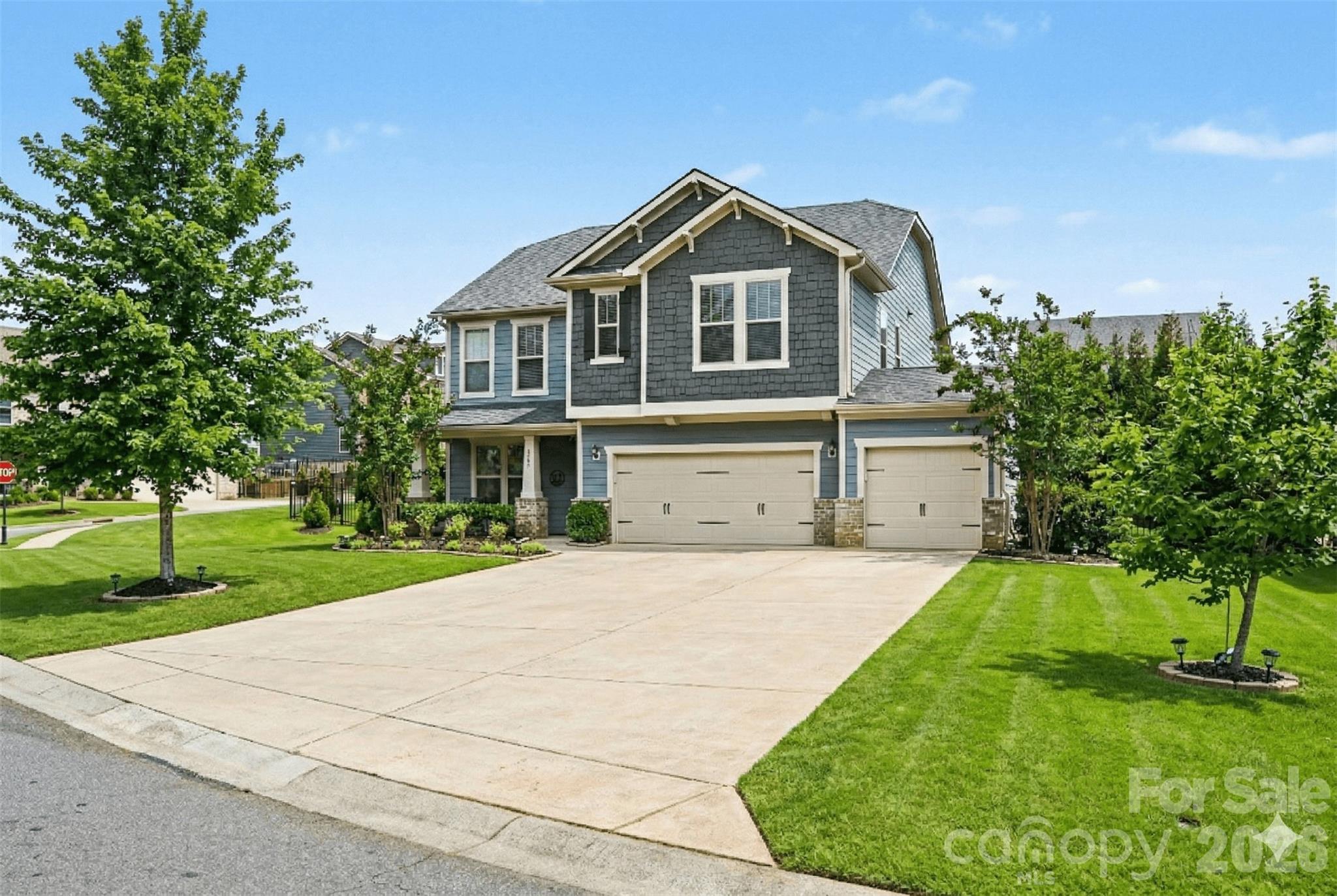 This exceptional Fort Mill home features over $100,000 in thoughtfully curated upgrades and is set on a rare .35-acre corner lot, one of the largest available for this floorplan, offering exceptional privacy and space. From the moment you arrive, the expanded driveway and oversized, epoxy-finished three-car garage make a striking impression, providing parking for up to nine vehicles and enhanced convenience with an Apple Home–enabled garage door system.

Inside, the home has been freshly painted and enhanced with updated interior lighting and newly added hardwood floors upstairs and along the staircase. The living room is highlighted by custom built-ins and a striking stone fireplace, creating a warm and inviting focal point. A first-floor guest suite with a full bath offers flexibility for visitors, multigenerational living, or a private home office.

Outdoor living truly sets this home apart. The exterior has been fully repainted and complemented by new fencing and added privacy trees, creating a serene backyard retreat. An expanded paver patio leads to a natural-gas firepit with lighted built-in seating, while the impressive covered patio features a stone outdoor kitchen complete with built-in grill, flat-top grill, refrigerator, and ice-maker hookup — ideal for year-round entertaining.

Major mechanical updates include newly replaced, zoned natural gas HVAC system, offering comfort and peace of mind. Located in a highly sought-after community, residents enjoy walking trails, a clubhouse, resort-style pool, two playgrounds, river access with kayak launch and pavilion, an 18-hole disc golf course, and an active social calendar. Convenient to shopping and dining and zoned for top-rated Fort Mill schools, this home offers a rare combination of space, privacy, and lifestyle!