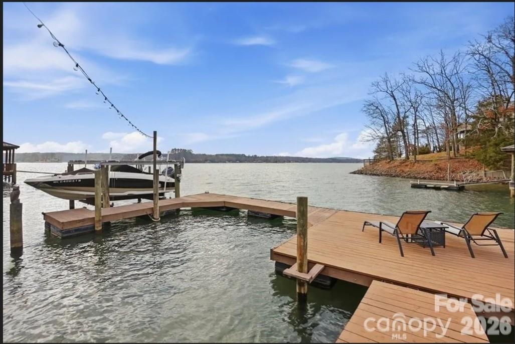 This one-of-a-kind Charleston-inspired waterfront estate is perfectly positioned along the shores of Lake Wylie, tucked at the end of a quiet private drive shared by only 3 other homes and no HOA. Offering approximately 4,187 SQ FT across 3 thoughtfully designed levels, every floor features its own covered porch or patio with sweeping, year-round lake views. The home's layout is exceptionally well-suited for multi-generational living or entertaining on a grand scale.  The lake-facing Great Room showcases breathtaking water views and opens to the dining area and kitchen. Renovated gourmet kitchen is beautifully appointed with Cambria quartz countertops, GE Profile appliances, a 5-burner cooktop, wall oven, custom hood, tile backsplash, and under-cabinet lighting. A formal dining room with classic wainscoting adds timeless charm. A spacious second primary suite on the main level (currently used as 2nd home office) features a walk-in closet, 2 additional storage closets, a cedar-lined closet, and a full bath.  Dedicated home office boasts incredible lake views, making it ideal for remote work. The guest and theater wing also includes a new electric fireplace, new full-size windows with a stunning lake view, a wired 7.1 home theater system with built-in speakers, and two built-in refrigerators - one for beverages and one for wine.  The 2nd floor is devoted to the primary suite with a cedar-lined walk-in closet, dressing area, oversized laundry room, spa like bath with heated floors, and a large private porch with unobstructed lake views. The lower level includes two bedrooms, each with its own en-suite bath (one full, one half), plus a comfortable sitting area and 2nd laundry. Designed for those who love to entertain and embrace lake life, enjoy boating, fishing, and swimming from your private dock with boat and jet ski lift, or relax on the covered dock sitting area.  Soak in the sun and peaceful surroundings on the private sandy lounge area.  Additional highlights include an oversized 3+ car garage with a dedicated workshop, wired for RV connection, abundant storage, parking for multiple vehicles, a simulated slate 50+ year roof, exquisite architectural details throughout, beautiful flooring, plantation shutters, and magnificent lake views. Great Palisades area location convenient to shopping, dining, and The Palisades Country Club.  Thoughtfully renovated and cared for, this exceptional waterfront retreat is luxury lake living at its finest.