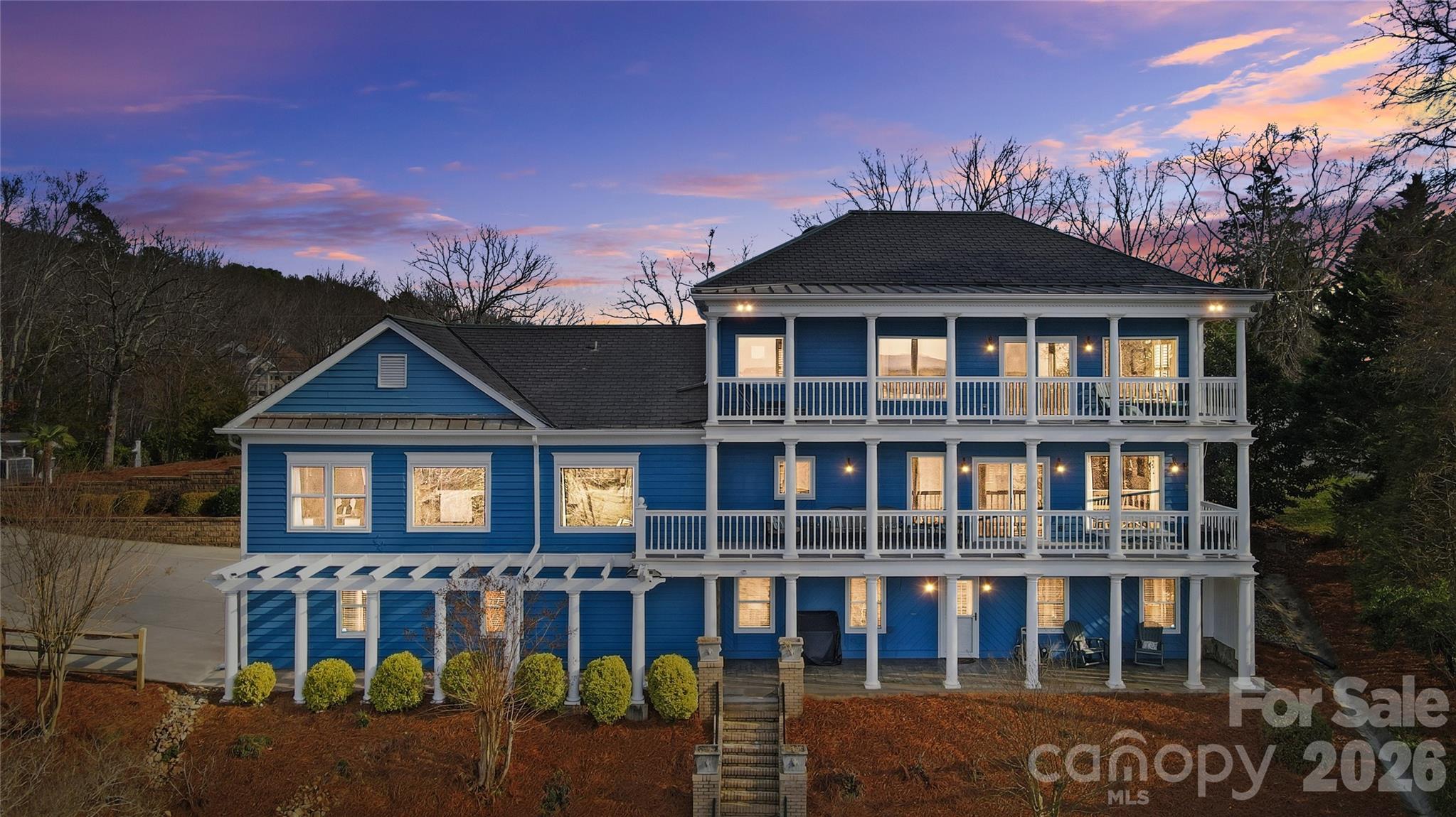 This one-of-a-kind Charleston-inspired waterfront estate is perfectly positioned along the shores of Lake Wylie, tucked at the end of a quiet private drive shared by only 3 other homes and no HOA. Offering approximately 4,187 SQ FT across 3 thoughtfully designed levels, every floor features its own covered porch or patio with sweeping, year-round lake views. The home's layout is exceptionally well-suited for multi-generational living or entertaining on a grand scale.  The lake-facing Great Room showcases breathtaking water views and opens to the dining area and kitchen. Renovated gourmet kitchen is beautifully appointed with Cambria quartz countertops, GE Profile appliances, a 5-burner cooktop, wall oven, custom hood, tile backsplash, and under-cabinet lighting. A formal dining room with classic wainscoting adds timeless charm. A spacious second primary suite on the main level (currently used as 2nd home office) features a walk-in closet, 2 additional storage closets, a cedar-lined closet, and a full bath.  Dedicated home office boasts incredible lake views, making it ideal for remote work. The guest and theater wing also includes a new electric fireplace, new full-size windows with a stunning lake view, a wired 7.1 home theater system with built-in speakers, and two built-in refrigerators - one for beverages and one for wine.  The 2nd floor is devoted to the primary suite with a cedar-lined walk-in closet, dressing area, oversized laundry room, spa like bath with heated floors, and a large private porch with unobstructed lake views. The lower level includes two bedrooms, each with its own en-suite bath (one full, one half), plus a comfortable sitting area and 2nd laundry. Designed for those who love to entertain and embrace lake life, enjoy boating, fishing, and swimming from your private dock with boat and jet ski lift, or relax on the covered dock sitting area.  Soak in the sun and peaceful surroundings on the private sandy lounge area.  Additional highlights include an oversized 3+ car garage with a dedicated workshop, wired for RV connection, abundant storage, parking for multiple vehicles, a simulated slate 50+ year roof, exquisite architectural details throughout, beautiful flooring, plantation shutters, and magnificent lake views. Great Palisades area location convenient to shopping, dining, and The Palisades Country Club.  Thoughtfully renovated and cared for, this exceptional waterfront retreat is luxury lake living at its finest.