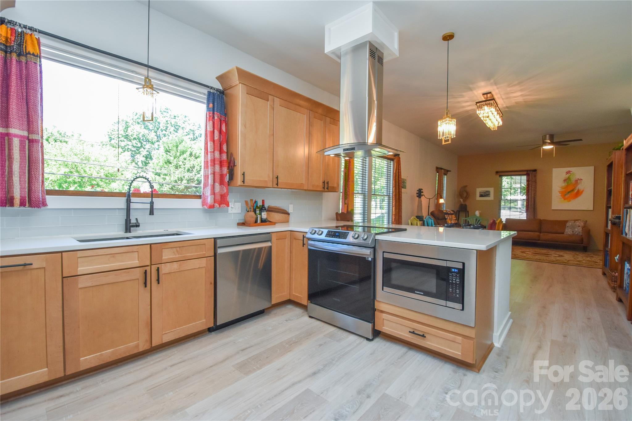 This beautifully restored property in Historic Downtown Mooresville has been brought back to life with exceptional attention to detail that is evident the moment you walk through the door. The soaring 10-foot ceilings set the tone across the entire main level. Natural light pours through new windows, illuminating the showstopping kitchen, which boasts  quartz countertops, soft-close cabinetry, a glass tile backsplash, a crystal chandelier, and stainless steel appliances. Thoughtful finishes are found throughout, from the upgraded wood plank laminate flooring to the fresh vinyl exterior that gives this classic home outstanding curb appeal.The spacious primary suite is a retreat with a beautifully appointed ensuite bath and an oversized walk-in closet. Upstairs features a third bedroom, a bonus room, and terrific finished storage! The backyard features lush privacy trees and the two covered porches invite you to slow down and enjoy a morning cup of coffee. Even the most discerning buyer will enjoy exploring the many updates and upgrades, which include: a new roof (2023), new HVAC (2023), new siding, new gutters, French drains, and a recently expanded driveway. Newly added Google Fiber available along Lowrance Ave! Ideally located in a highly-rated school district and just a short stroll from Mooresville Golf Course and vibrant Downtown Mooresville - restaurants, boutique shopping, golf, and community events are all within easy reach (including the upcoming revitalization of Moor Park just up the road). This home, nestled on 1/3 of an acre is move-in-ready and has been renovated with care from top to bottom. Properties like this don't come around often - schedule your private showing today!