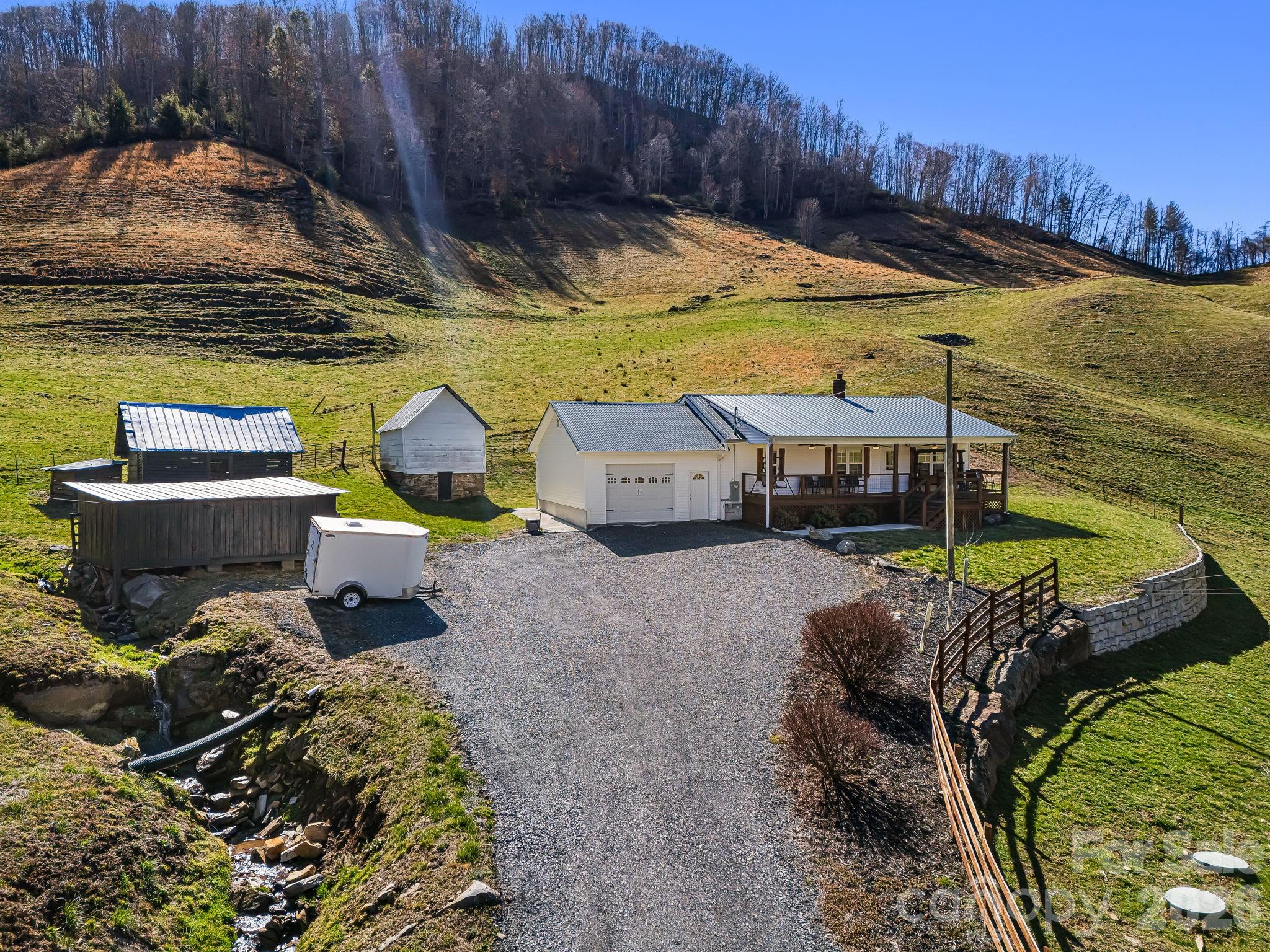 SELLER OFFERING OWNER FINANCING! REDUCED TO SELL! Welcome to 867 Indian Creek Rd—your mountain dream retreat nestled in the heart of Burnsville, NC. Set on 63 acres of unrestricted land, this one-of-a-kind property offers endless possibilities. From homesteading to multigenerational living or simply enjoying peace and privacy of wide-open space, this is a rare find. The beautifully completely updated farmhouse features 2 cozy bedrooms, 1 full bath, and timeless charm throughout. Step outside to discover a spring house, a large barn perfect for animals or storage, and a soothing creek that runs through the land. Located a short drive to downtown Burnsville, Asheville, NC, and Johnson City, TN. Whether you’re seeking serenity or a place to build your vision, this property is ready to welcome you home. Don’t miss out—schedule your private tour today and experience the magic of Indian Creek for yourself.