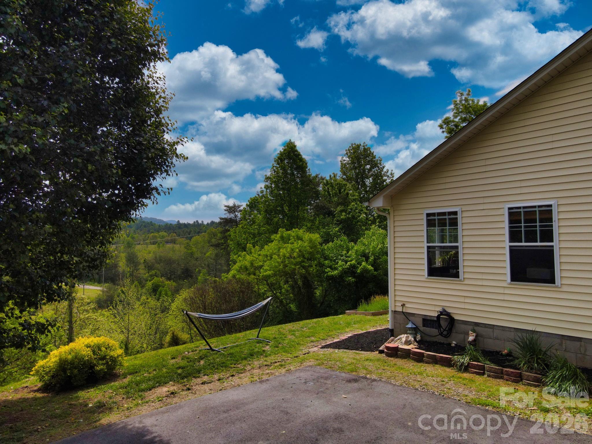 Looking for a convenient home in Weaverville? Look no further... 

Tucked on a mountain just outside of Weaverville (no joke! 10 minutes to downtown Weaverville and 5 minutes to North Buncombe High School), this inviting mountain home offers the perfect blend of comfort, charm, and convenience. Surrounded by greenery and mountain views, you’ll love the sense of privacy while being only about 5 minutes from the future AdventHealth Weaverville hospital campus.

Inside, the home welcomes you with warm hardwood floors, soaring ceilings, and a stunning stacked stone fireplace that anchors the spacious living area. Large windows invite natural light and frame the surrounding trees, creating a bright yet cozy atmosphere throughout. Buyers will appreciate this single level home for ease of living.

Head outside to enjoy everything buyers love about living in Weaverville, NC — fresh mountain air, privacy, and outdoor living. Relax in the hammock with long-range views, gather around the fire pit beneath the trees, or entertain in the beautifully shaded yard that feels like your own private retreat. There's a freshly painted back deck complete with a hot tub for maximum relaxation!

There is an outbuilding for storage and additional uses as half of it has been turned into an office for those remote workers. 

Enjoy quick access to hiking, local breweries, restaurants, shopping, and the vibrant arts and music scene of both Weaverville and Asheville while still enjoying the privacy and serenity of mountain living. This is the perfect opportunity to own a peaceful home in one of the most desirable areas of Western North Carolina.