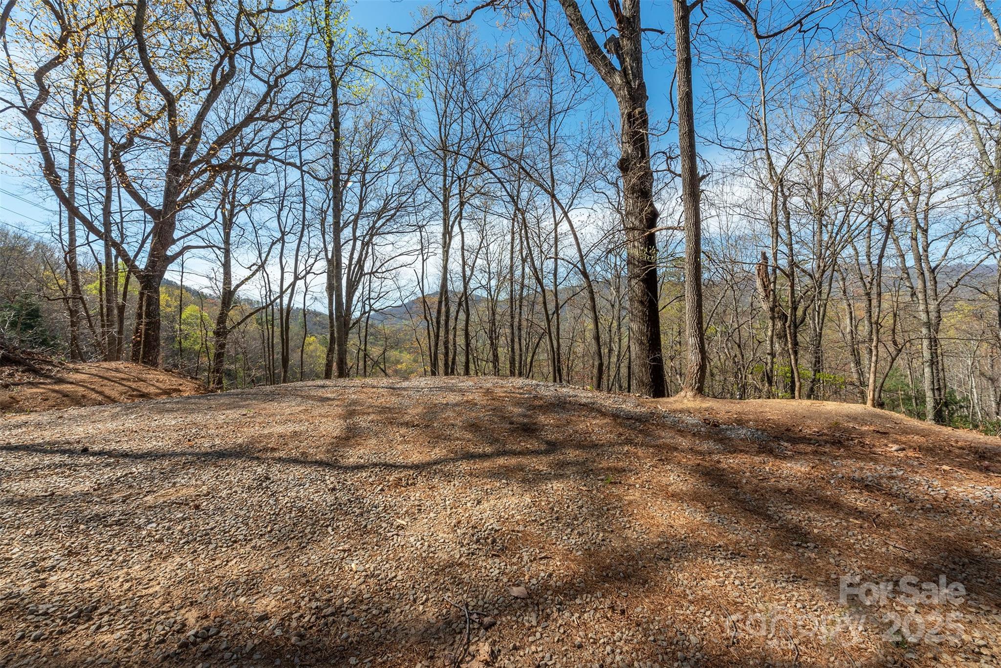 Coveted piece of historical property being released for SFR development for first time since the early 1900s. This 1.25ac+/- lot on Sunset Mountain lays well for your perfect mountain house. Views of the Black Mountain Range north & all sunsets west. Nicely wooded with an older portion of the original historical roadbed now providing a rough driveway that originally led ole Model-Ts from downtown to the top of Sunset Mountain (aka "Miami Mountain" as named by early 1900s Miami developer). Near to our little village, you may access downtown quickly through a small neighborhood gate behind the Black Mt Welcome sign across from I-40E @x-64 RL. Ride your bike down Sunset or choose to leisurely walk into downtown from this property. Future accessibility of the Town's new 30+ac Park as gated/joins off Sunset Drive...Once the Park is sufficiently developed/opened by the Town for public use/enjoyment. Attached interesting historical articles on Sunset Mt...