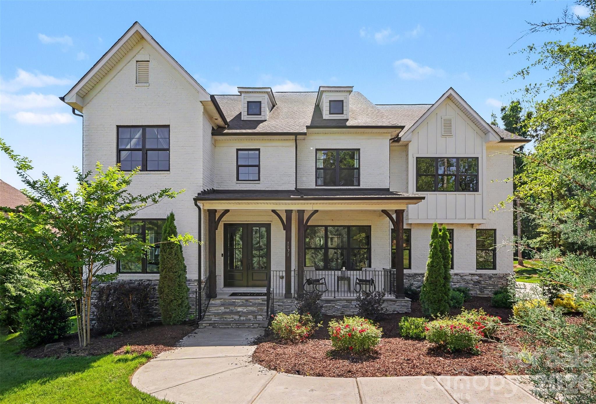 Welcome to this truly exceptional full-brick custom estate, perfectly situated on a beautifully landscaped one-acre homesite in the highly sought-after, award-winning Fort Mill School District. Offering the ideal balance of luxury, privacy, and thoughtful design, this remarkable home showcases upscale finishes, expansive living spaces, and resort-style outdoor amenities designed for both everyday living and unforgettable entertaining.

From the moment you enter, you're greeted by an impressive foyer, elegant staircase, and abundant natural light that fills the home. The thoughtfully designed main level features a dedicated home office, formal living room, spacious dining room accented with craftsman-style molding, powder room, and a private in-law suite with a full bath—ideal for visitors or multigenerational living.

At the heart of the home is the stunning two-story great room, highlighted by cedar box beam detailing, a 48-inch linear fireplace with blower and remote, and a dramatic 16-foot bi-parting sliding glass door that seamlessly connects indoor and outdoor living spaces.

The chef's kitchen was designed to impress, featuring premium GE Monogram appliances including a 48-inch built-in refrigerator, 36-inch dual-fuel range, wall oven, custom Kith Homestead maple cabinetry, an oversized center island, walk-in pantry with custom shelving, and a butler's pantry complete with wine cooler.

Upstairs, the luxurious owner's retreat offers a private sanctuary with a vaulted ceiling, cedar beam accents, motorized shades, dual custom-designed walk-in closets, and a spa-inspired bath featuring a freestanding soaking tub, oversized tiled shower, separate vanities, and additional motorized shades for privacy and convenience.

Generously sized secondary bedrooms provide large closets and ample space for family and guests. A dedicated media room—with projector included—and adjoining half bath create the perfect setting for movie nights, game days, or entertaining.

Step outside and discover a backyard retreat designed for year-round enjoyment. The custom outdoor kitchen features premium Coyote appliances and is complemented by an expansive travertine paver patio, Trex decking with cable railing, and a covered porch equipped with motorized screens and a motorized pergola system—creating the ultimate indoor-outdoor lifestyle experience. Septic placement thoughtfully designed to accommodate a future pool installation

The property extends well beyond the firepit into the wooded area, creating a private setting reminiscent of neighboring estate lots while still offering usable outdoor space for recreation and relaxation.

Located just minutes from shopping, dining, and everyday conveniences—with a new grocery store opening nearby—this extraordinary property offers a rare opportunity to enjoy luxury living, exceptional craftsmanship, and one of the most desirable locations in Fort Mill.