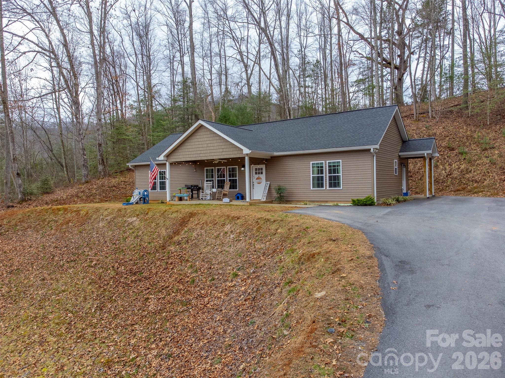 Built in 2021, this 3 bedroom, 2 bath home features a well planned layout with an open living area and split bedroom design. The kitchen offers plenty of space to cook and gather, complete with a large island, pantry, and generous storage. The primary bedroom is oversized, while the two additional bedrooms provide comfortable space for guests or a home office. A mudroom entry makes everyday living easier, offering a convenient spot to transition from outside and access the laundry area. Located in the Savanah area, this home allows for an easy drive to both Sylva and Franklin. With a newer roof, HVAC, and a paved driveway, this property offers the benefits of newer construction with practical features throughout.